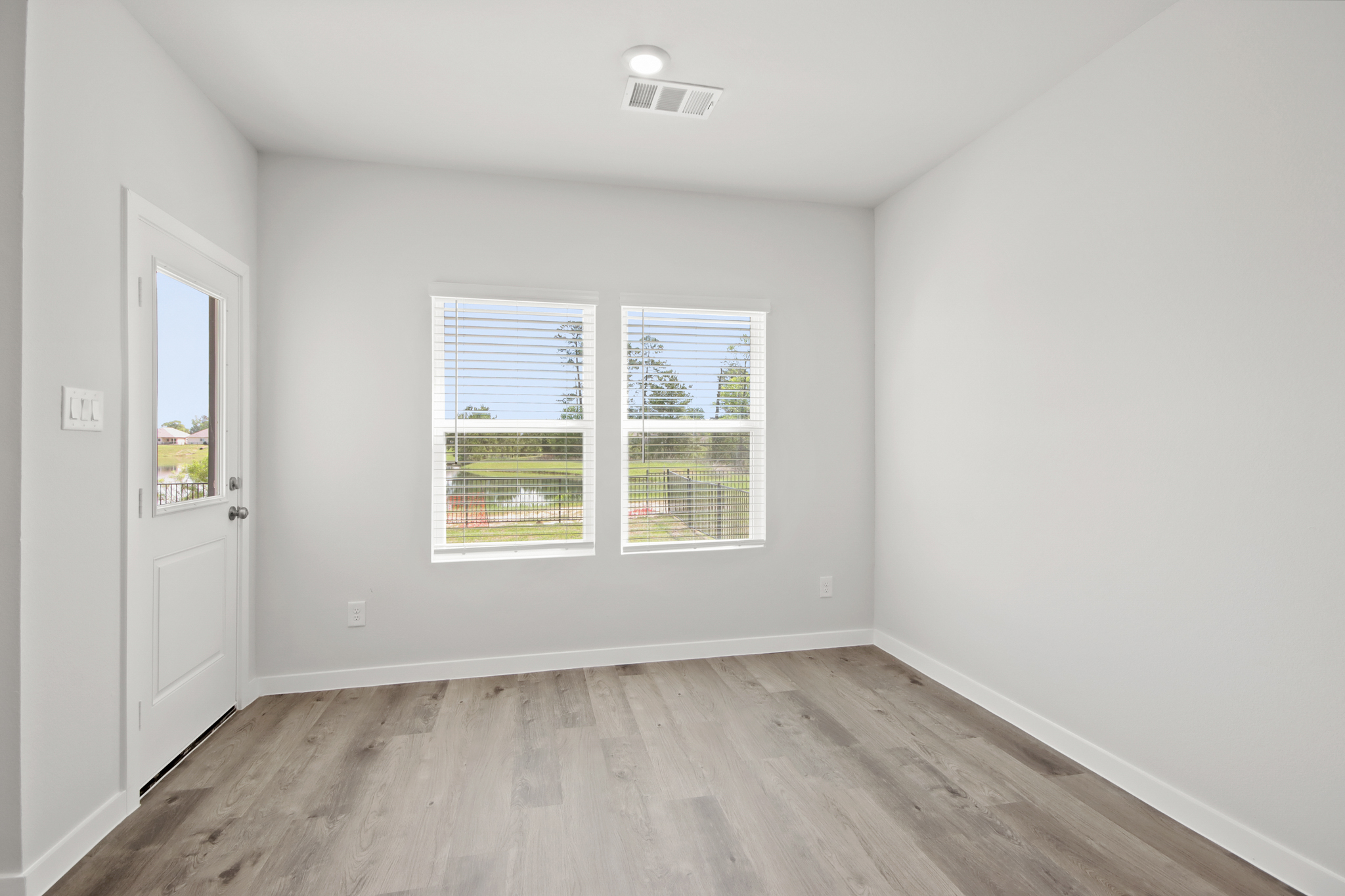 A room with a wood floor and windows.