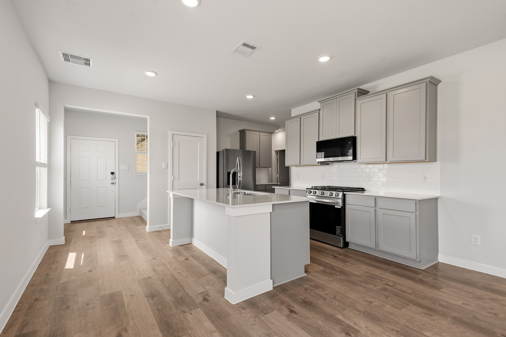 A kitchen with white cabinets.