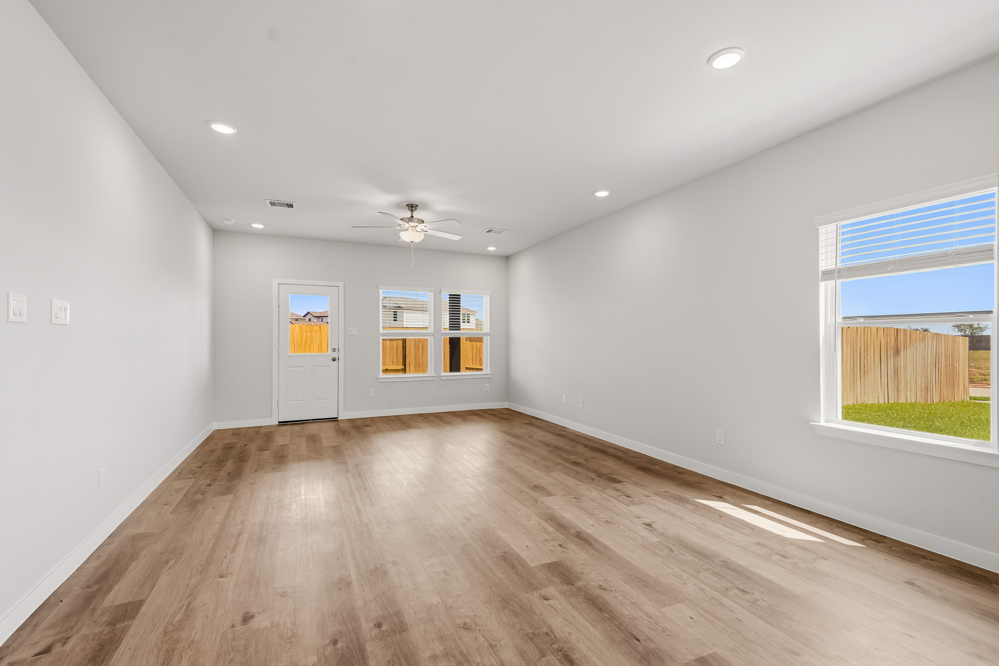 A room with a wood floor and windows.