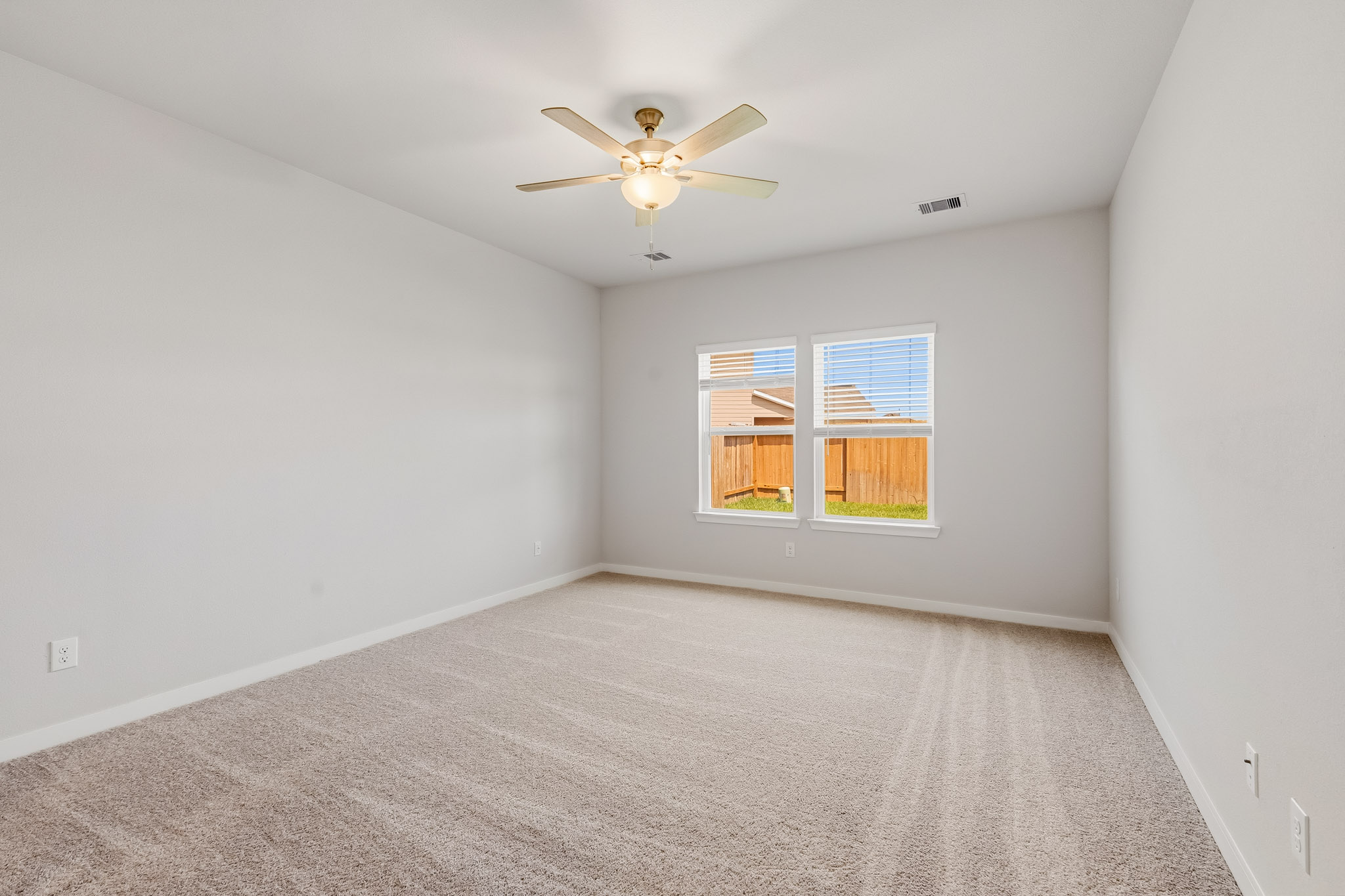 A room with a ceiling fan and a window.