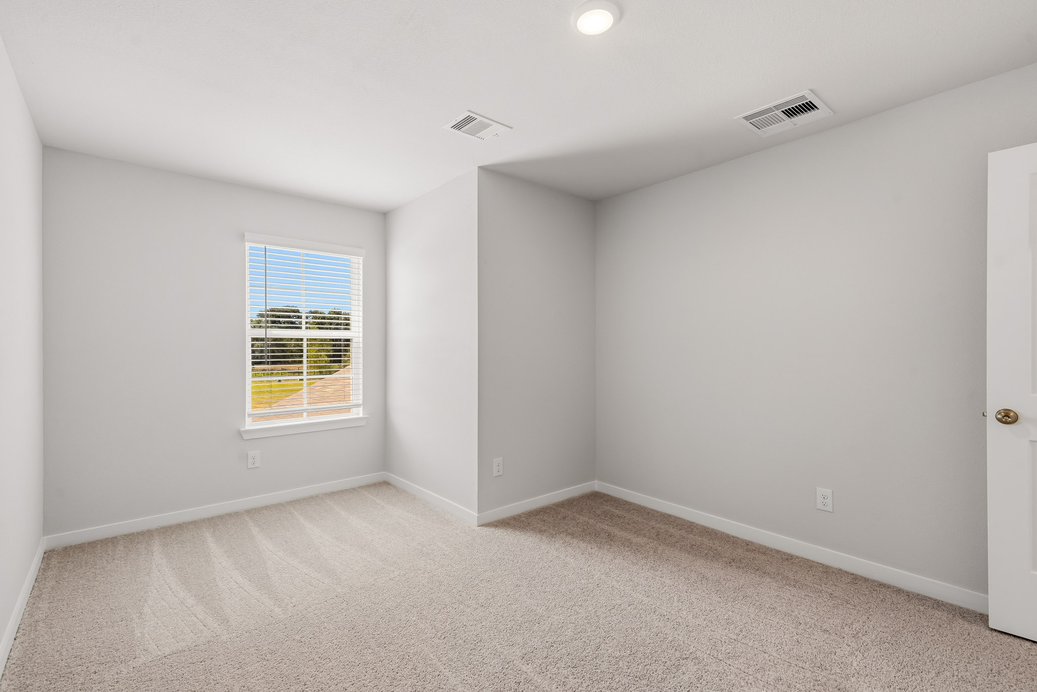 A room with a window and a carpet.