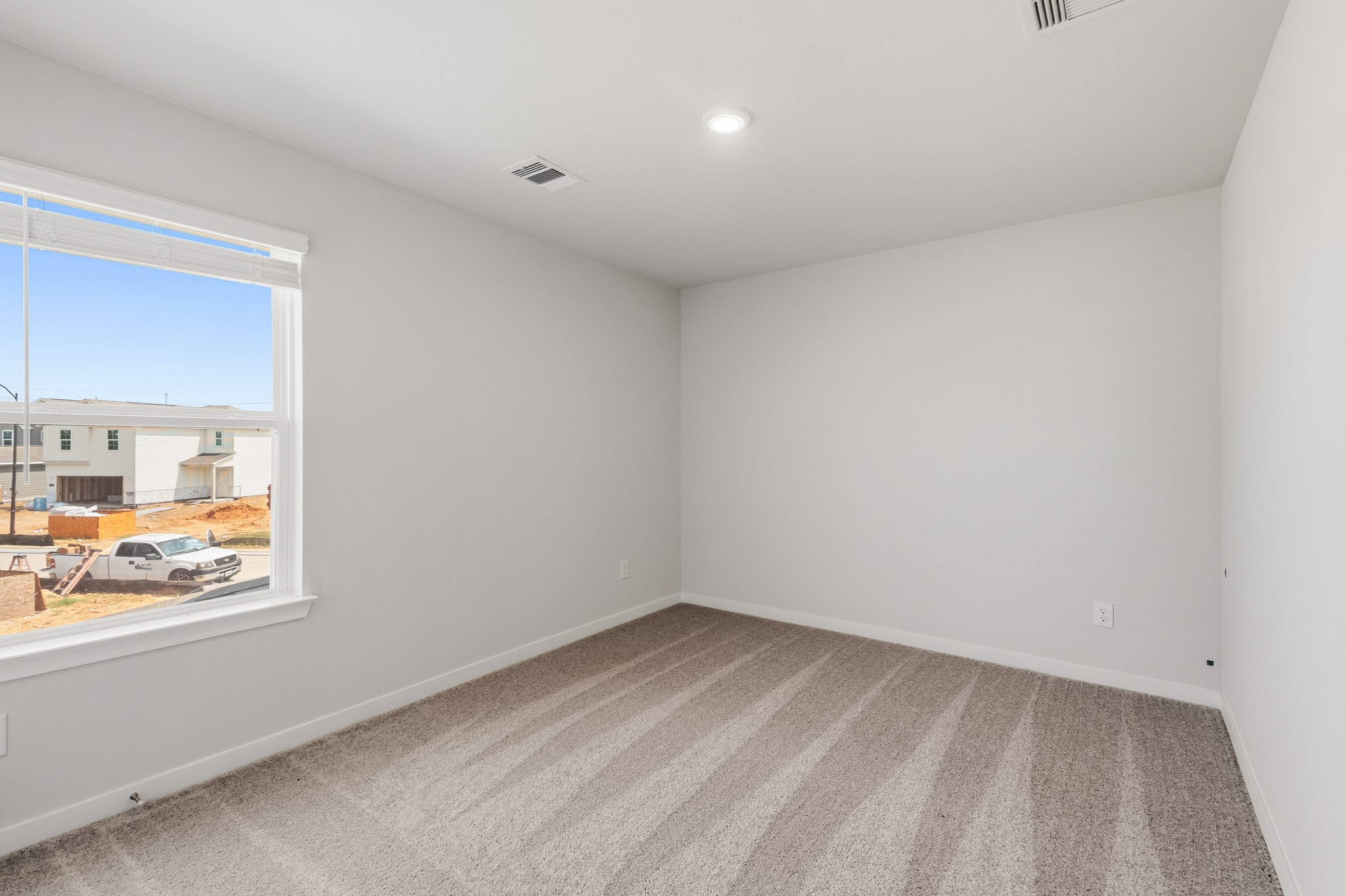 A room with a window and a white wall.