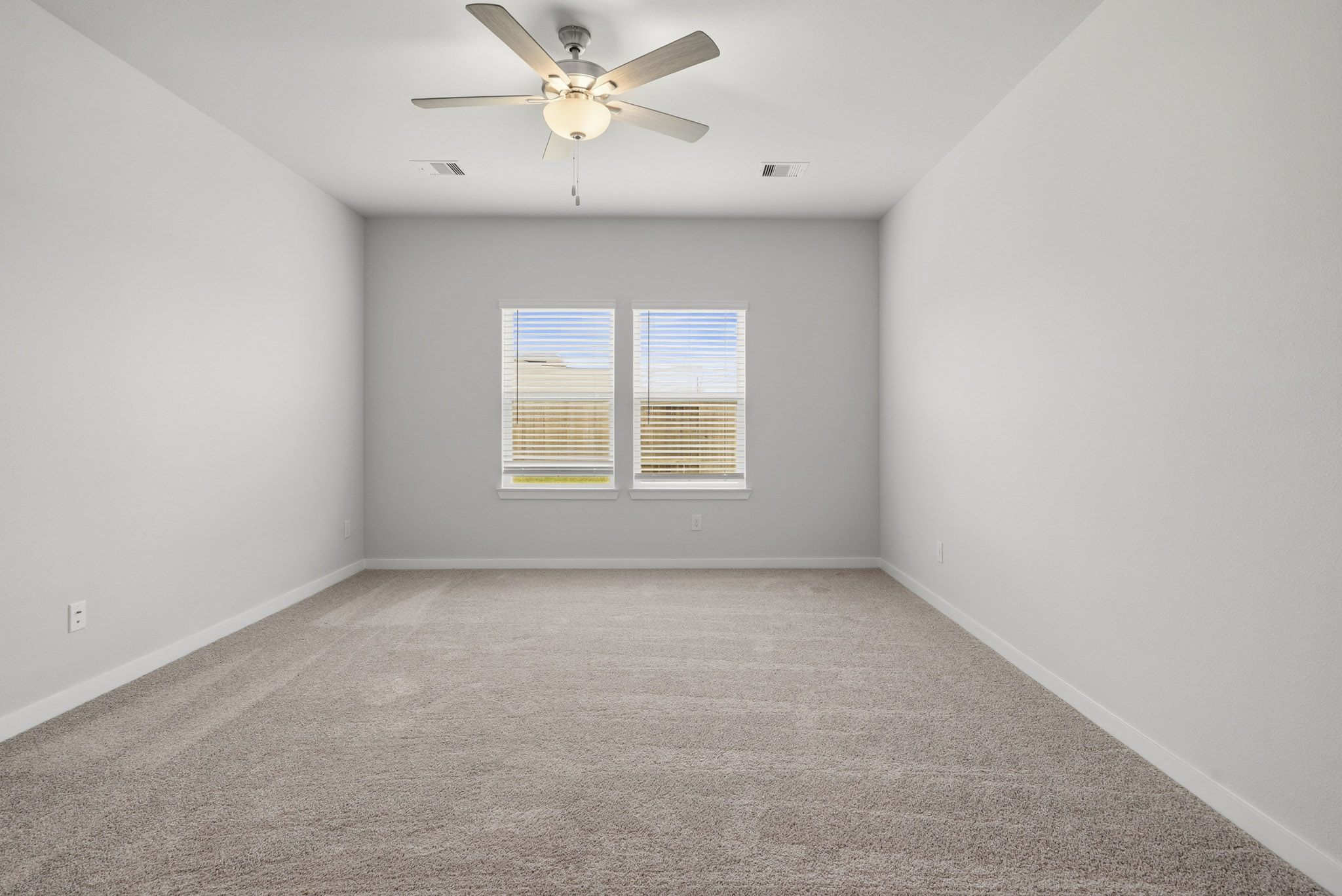 A room with a ceiling fan and a window.