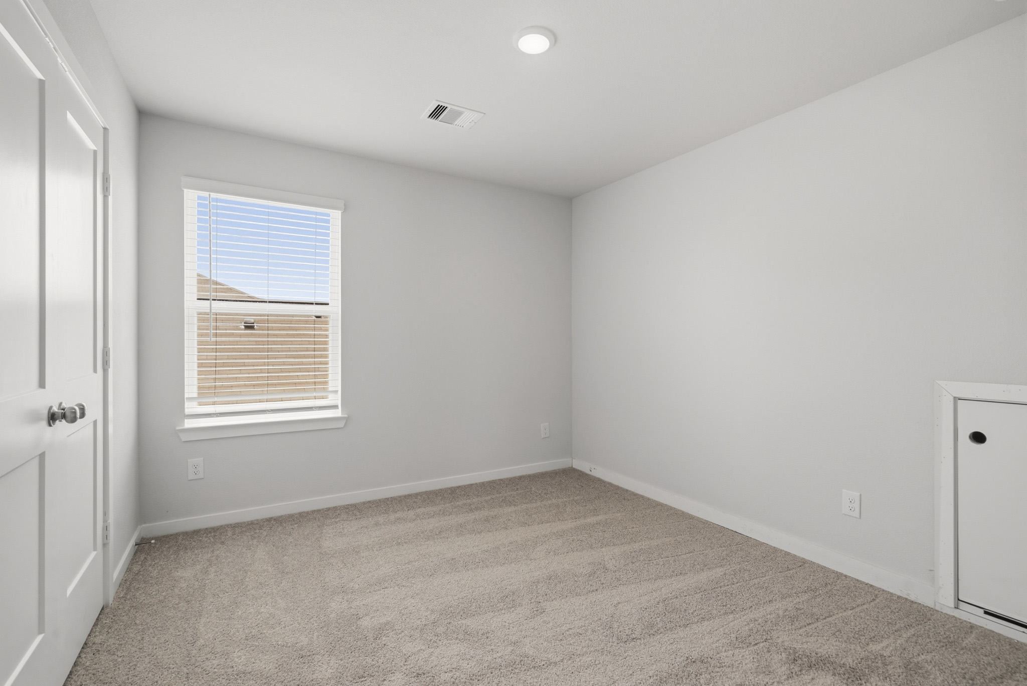 A room with a carpet and a window.