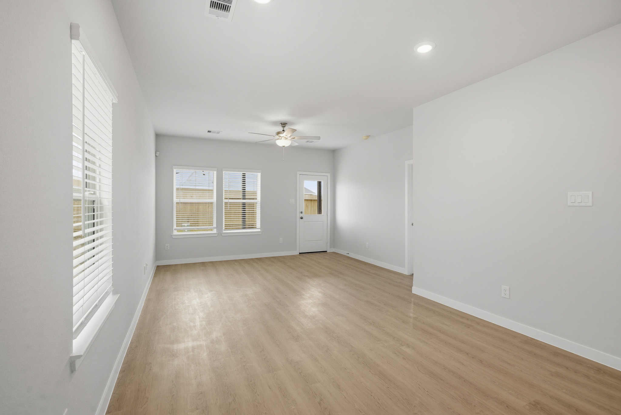 A room with a wood floor and a ceiling fan.