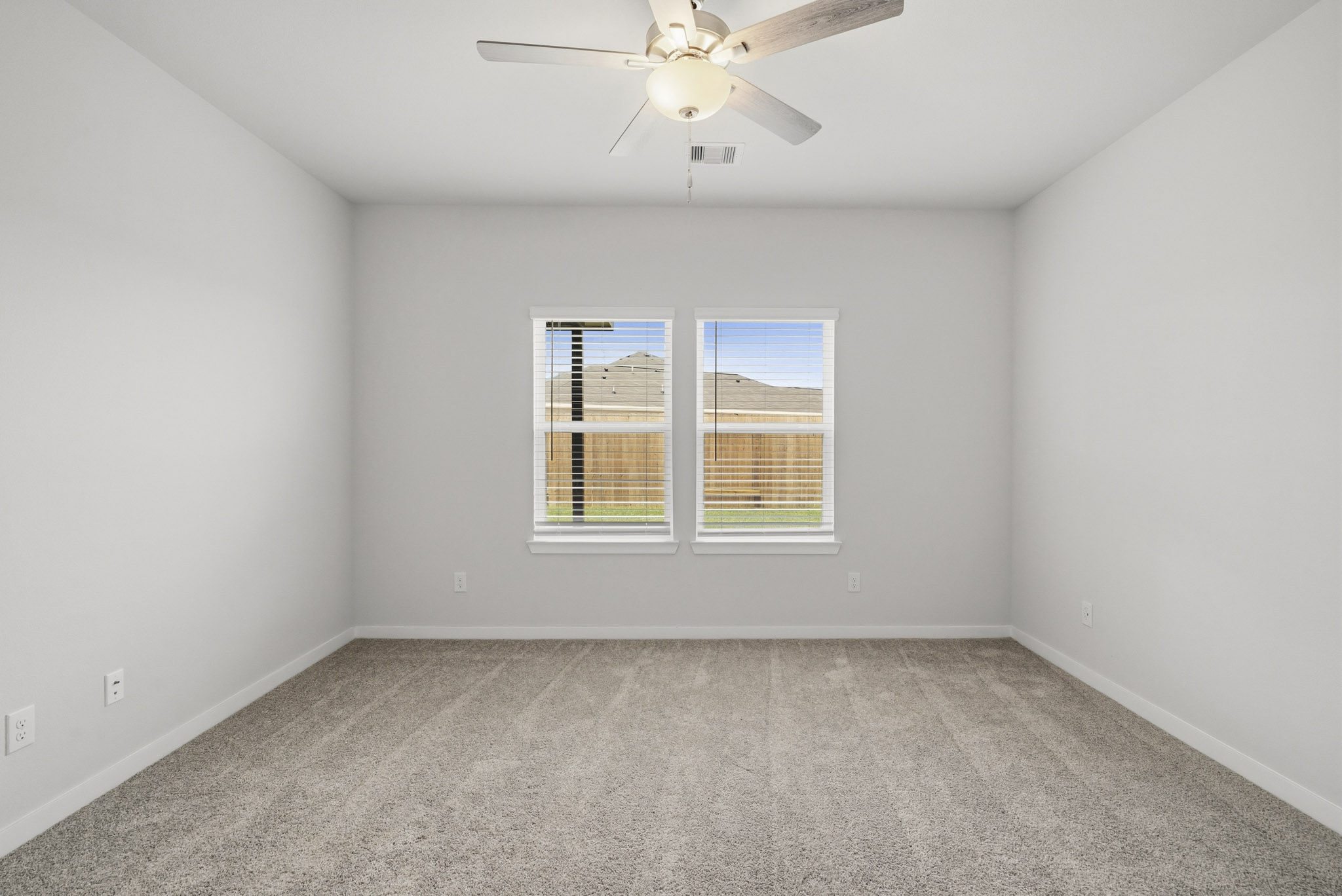 A room with a ceiling fan and a window.