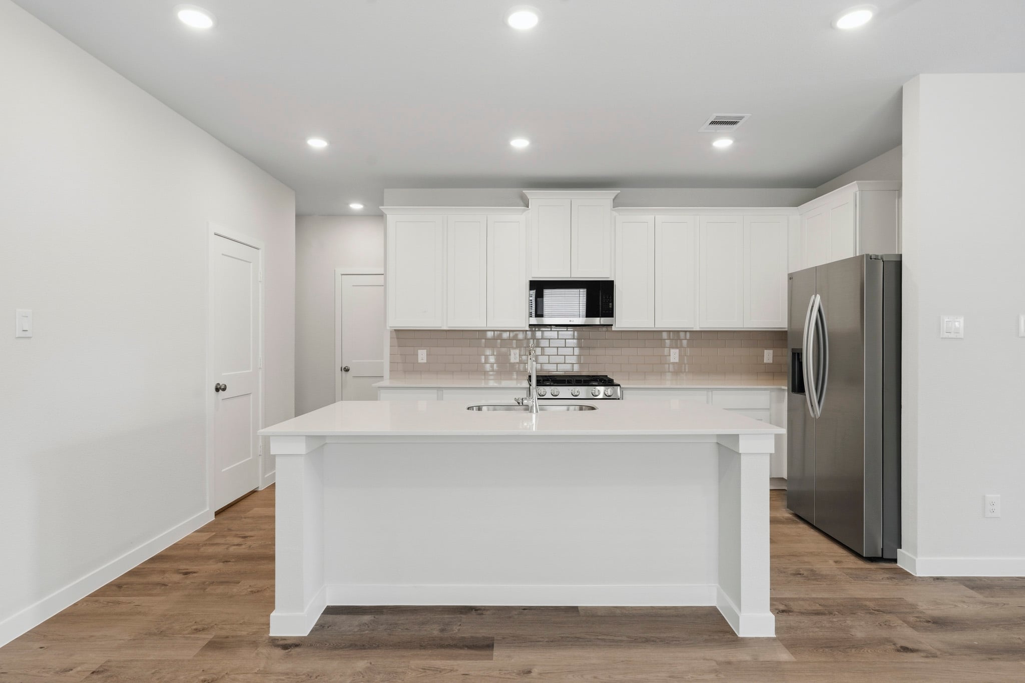 A kitchen with white cabinets.