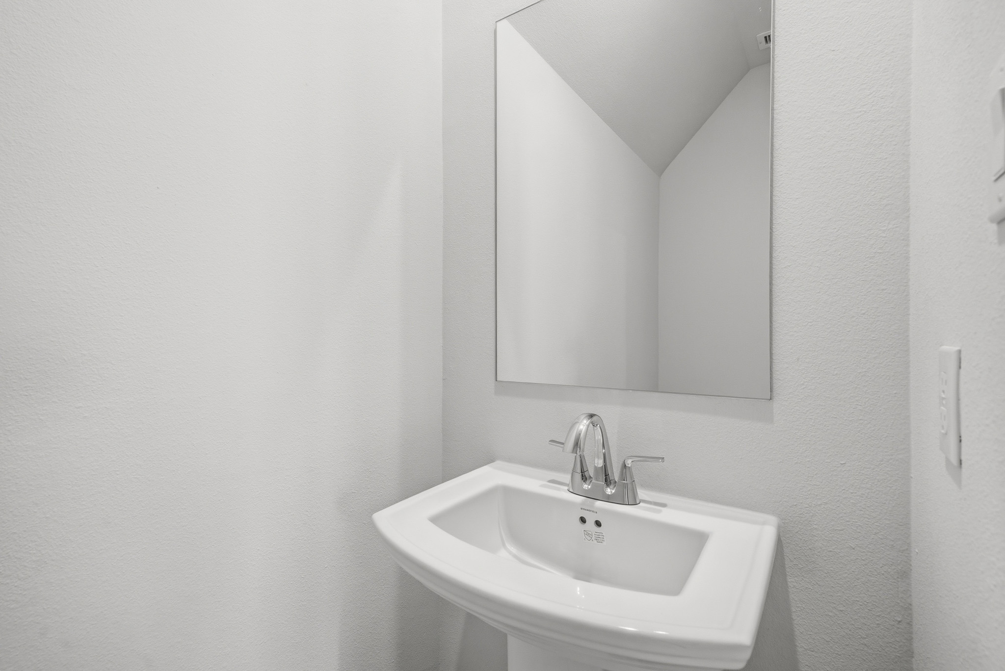 A bathroom with a mirror and sink.