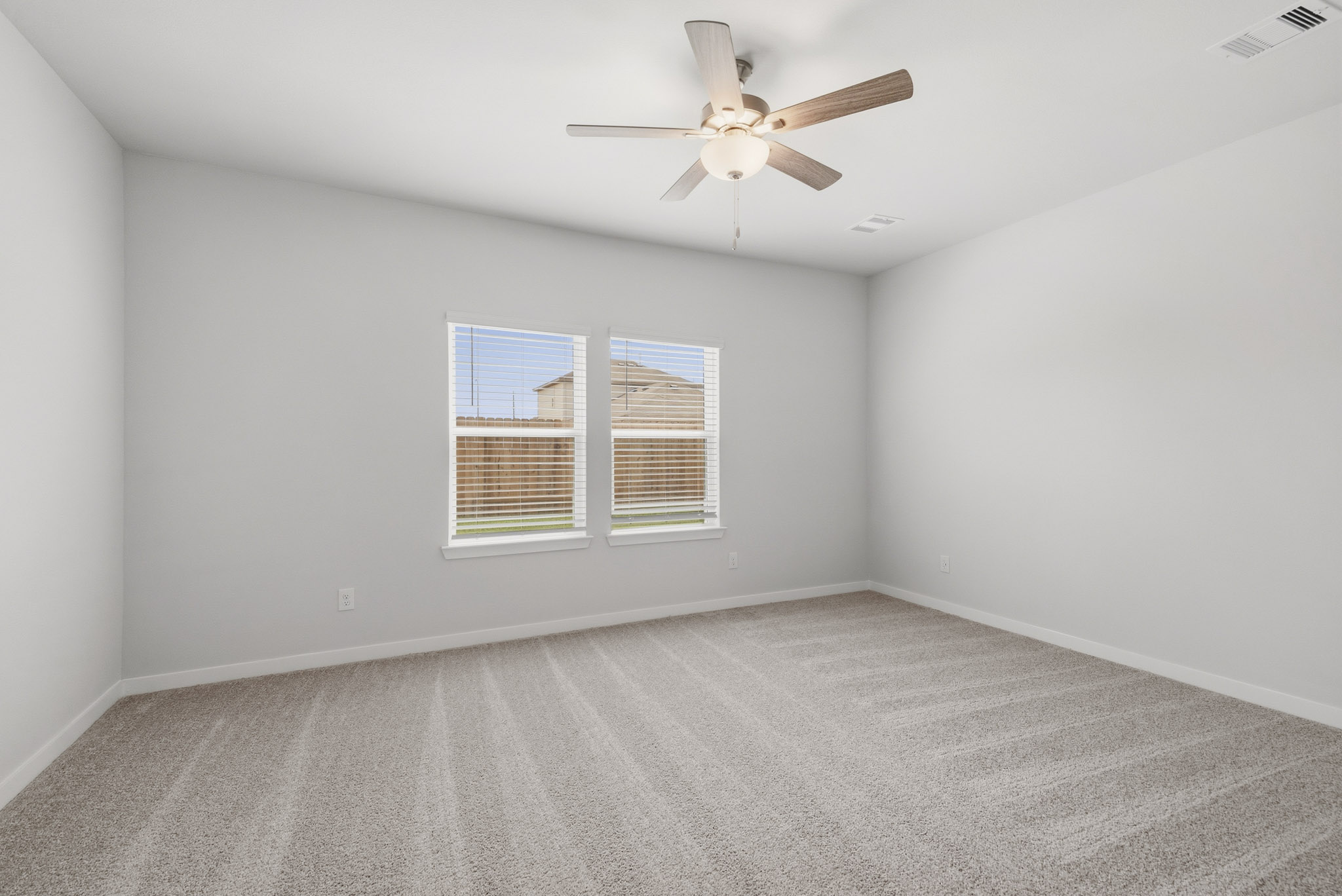A room with a ceiling fan and a window.