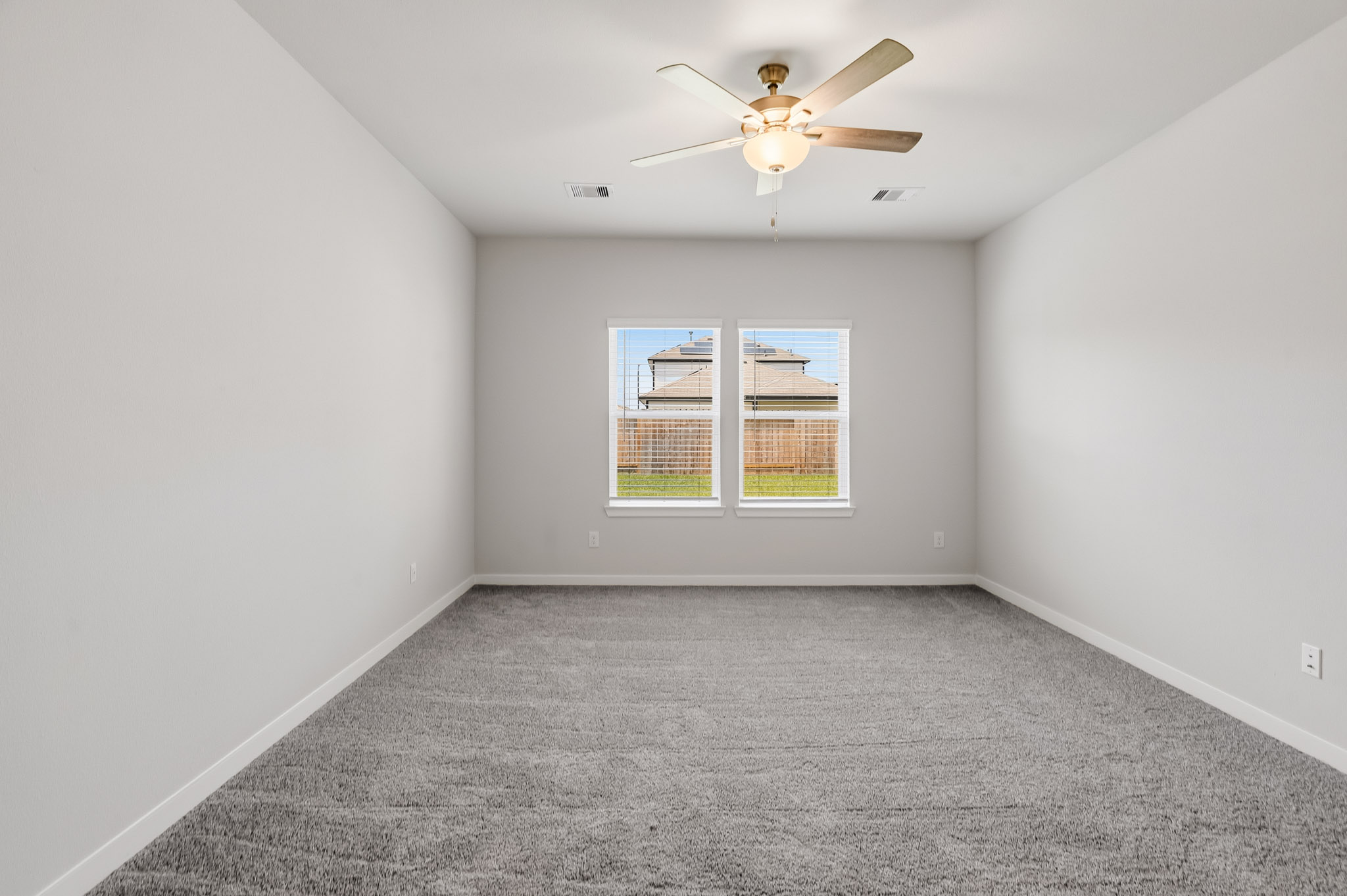 A room with a ceiling fan and a window.