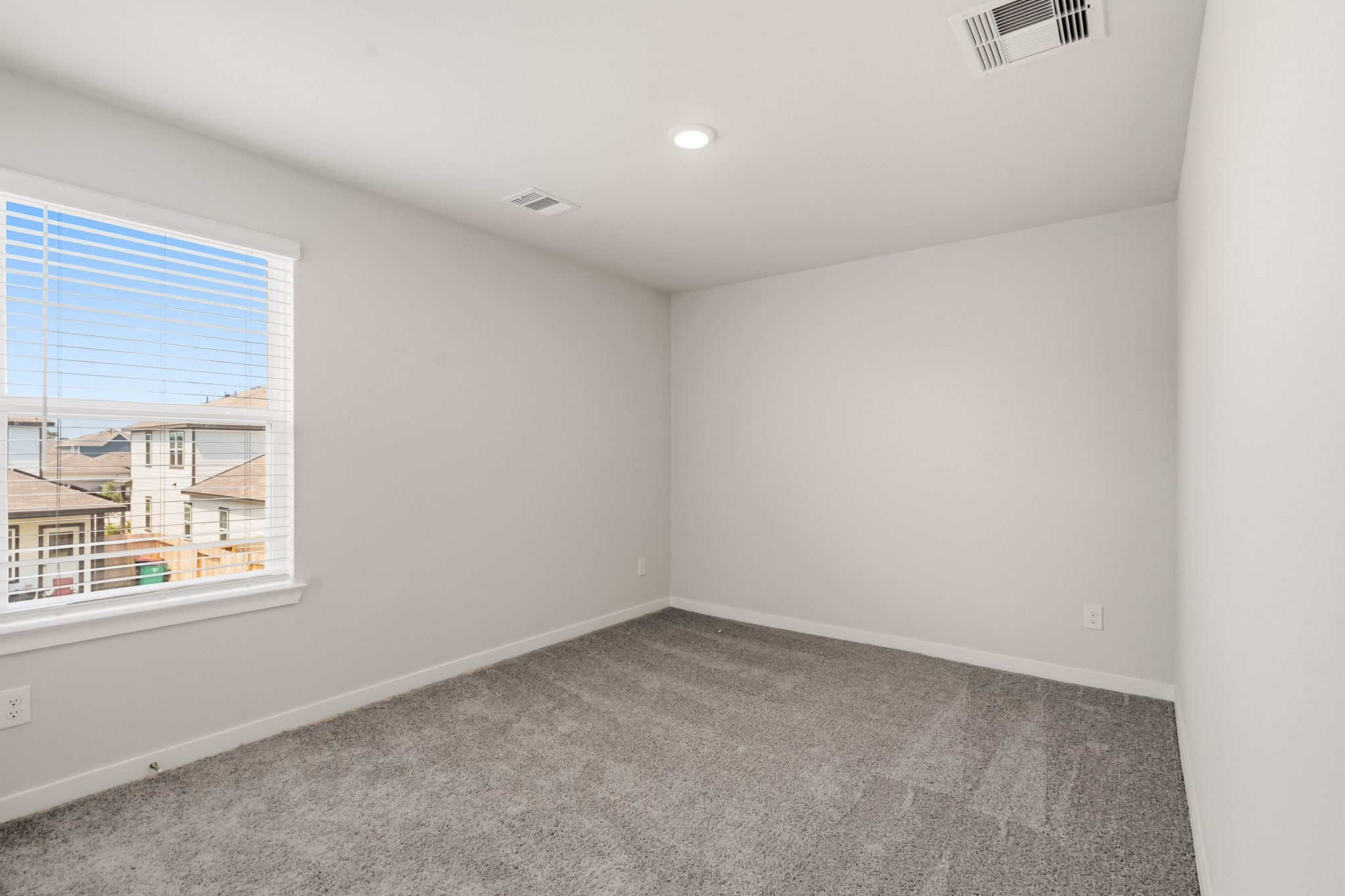 A room with a window and a carpet.
