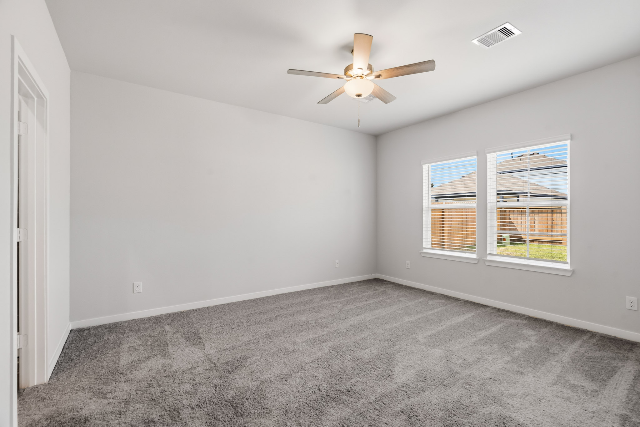 A room with a ceiling fan and a window.