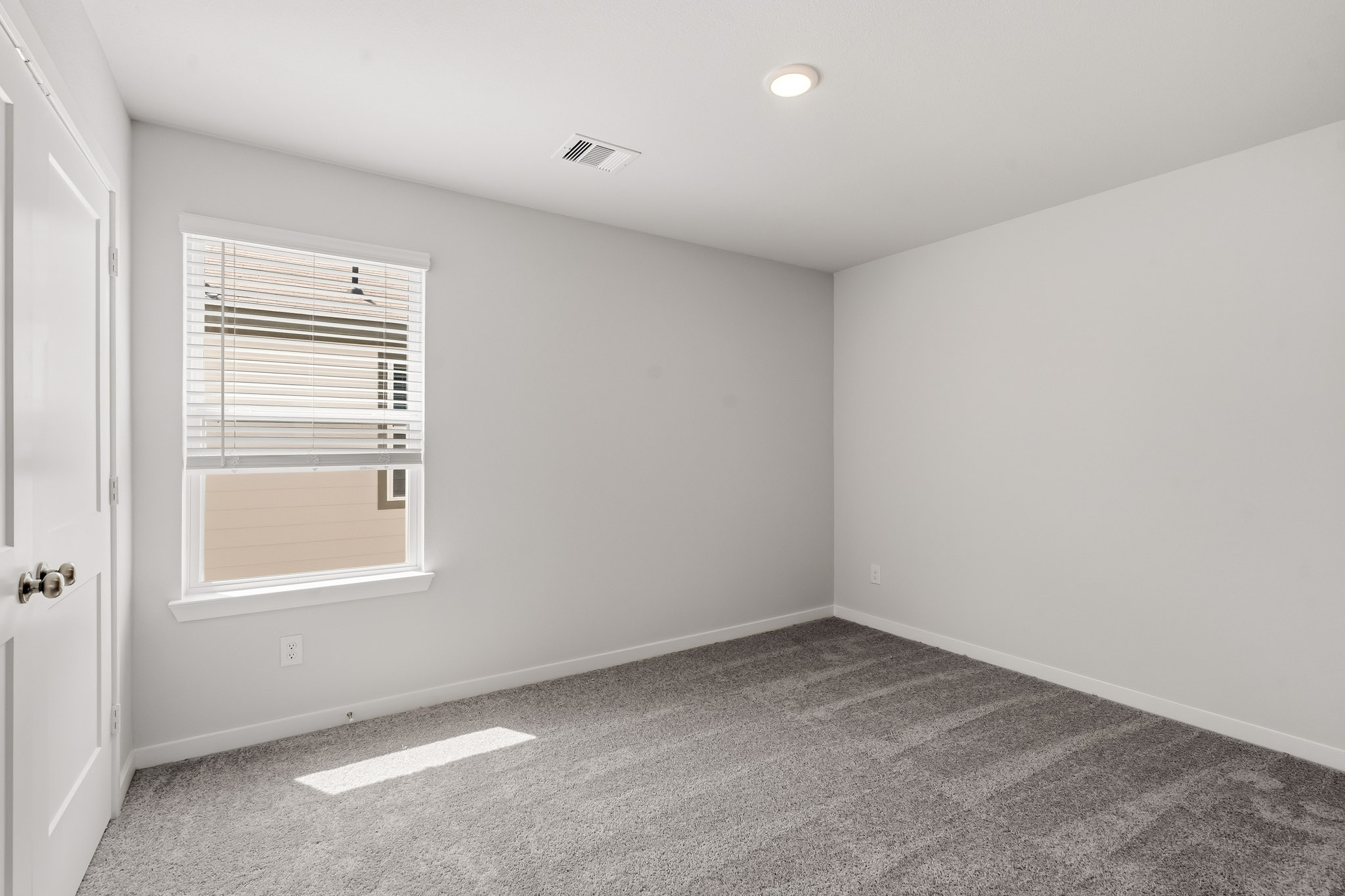 A room with a window and a carpet.