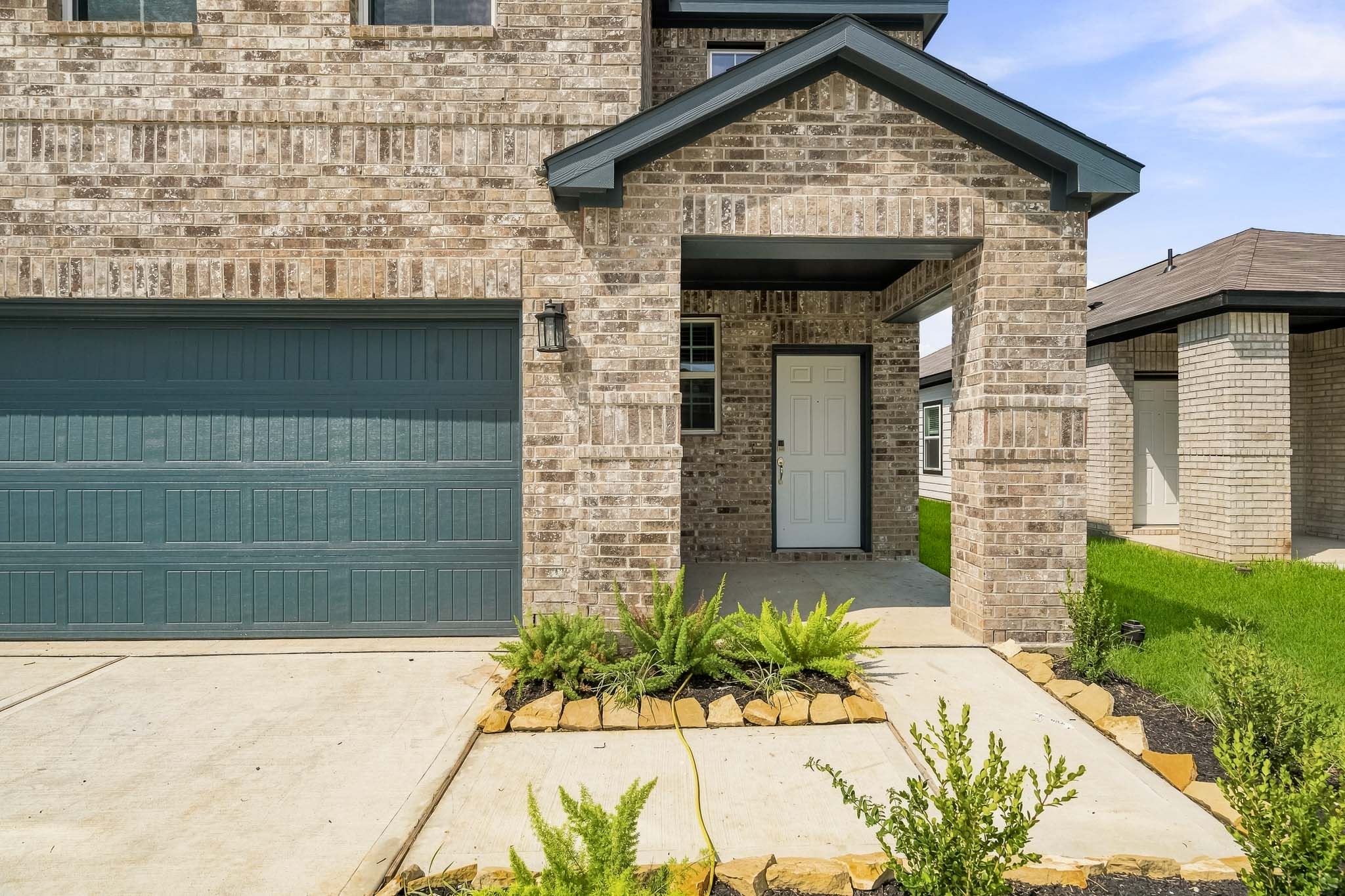 A building with a garage and a green door.