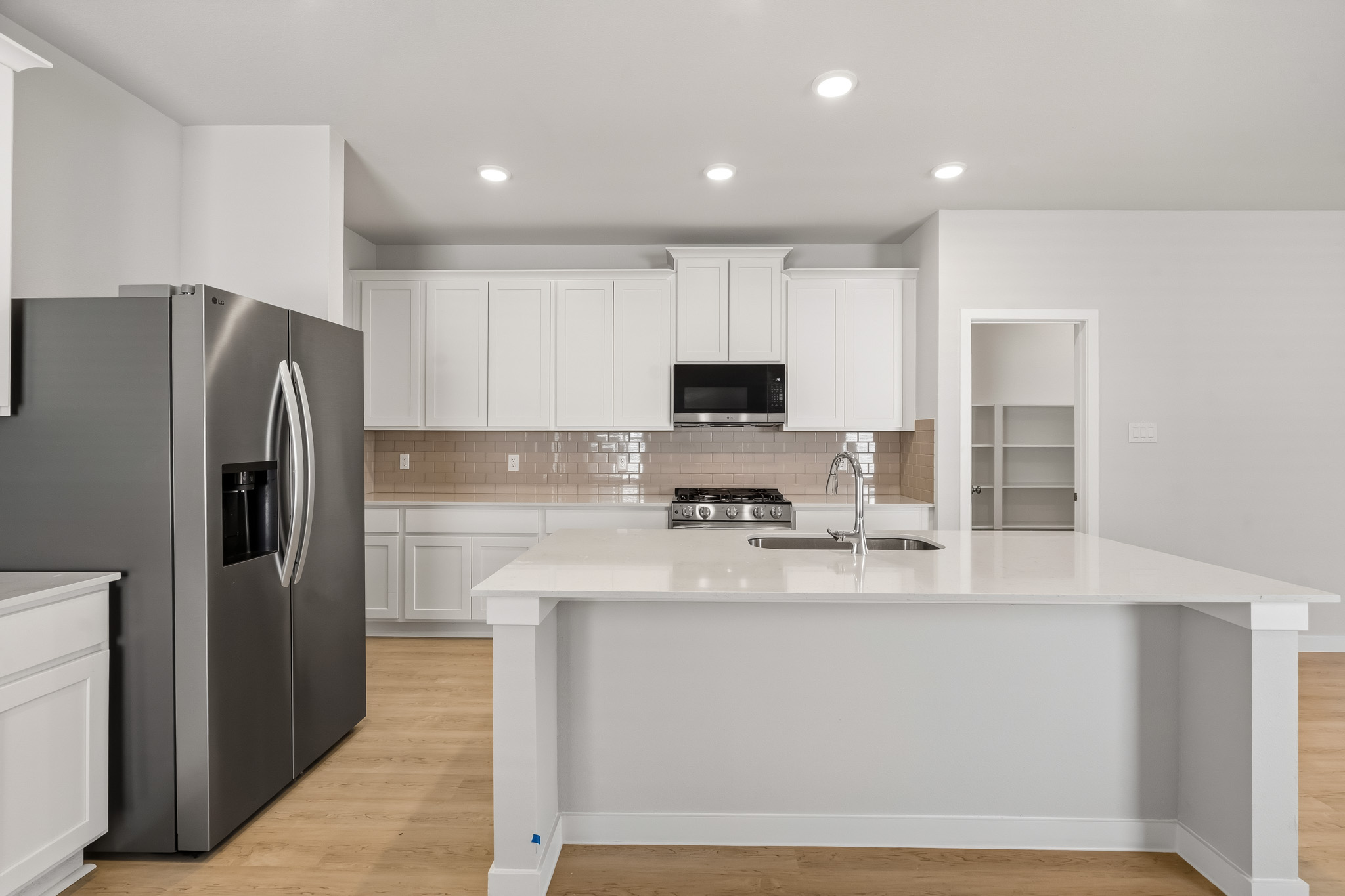 A kitchen with white cabinets.
