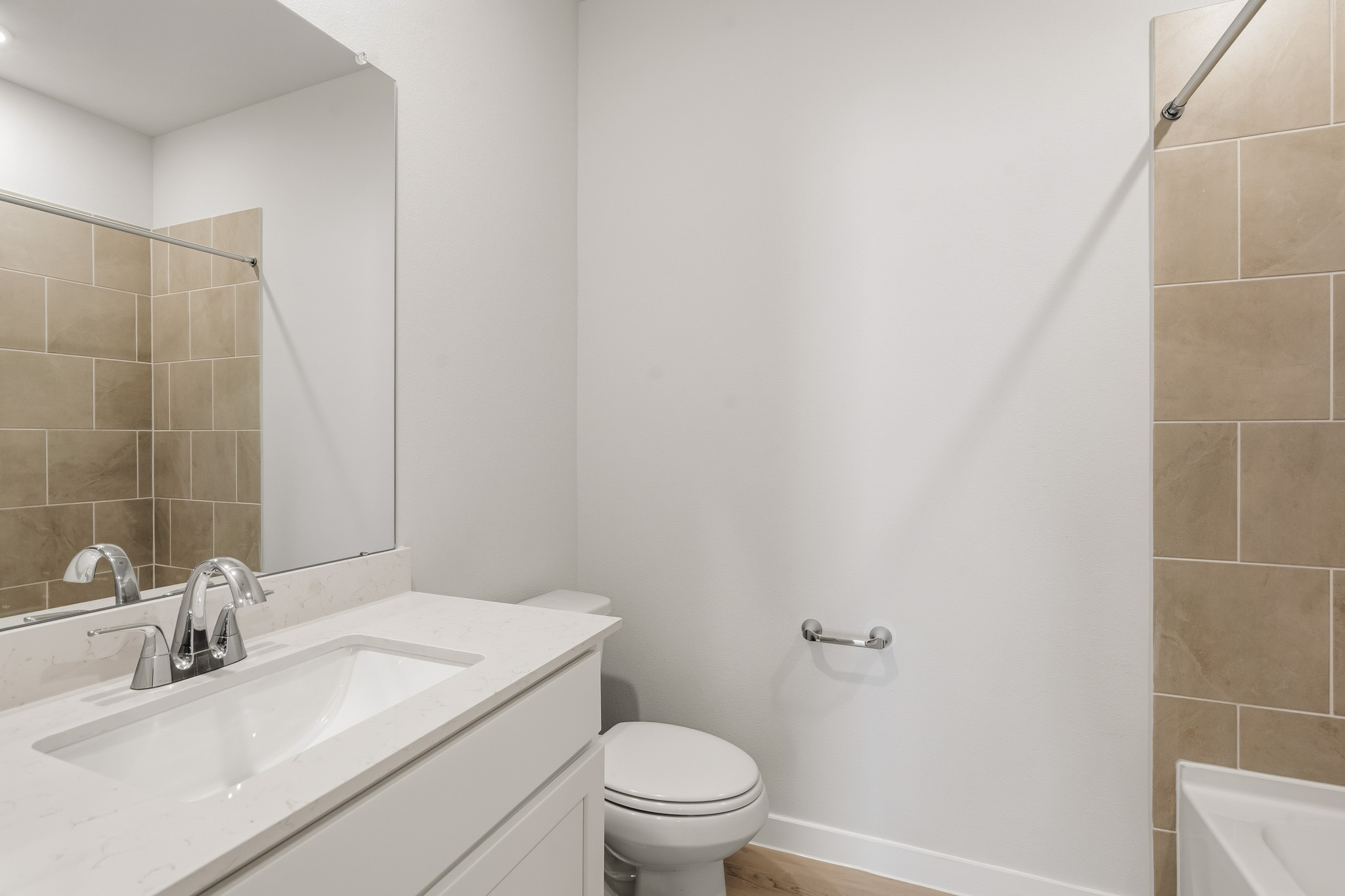 A bathroom with a sink toilet and mirror.