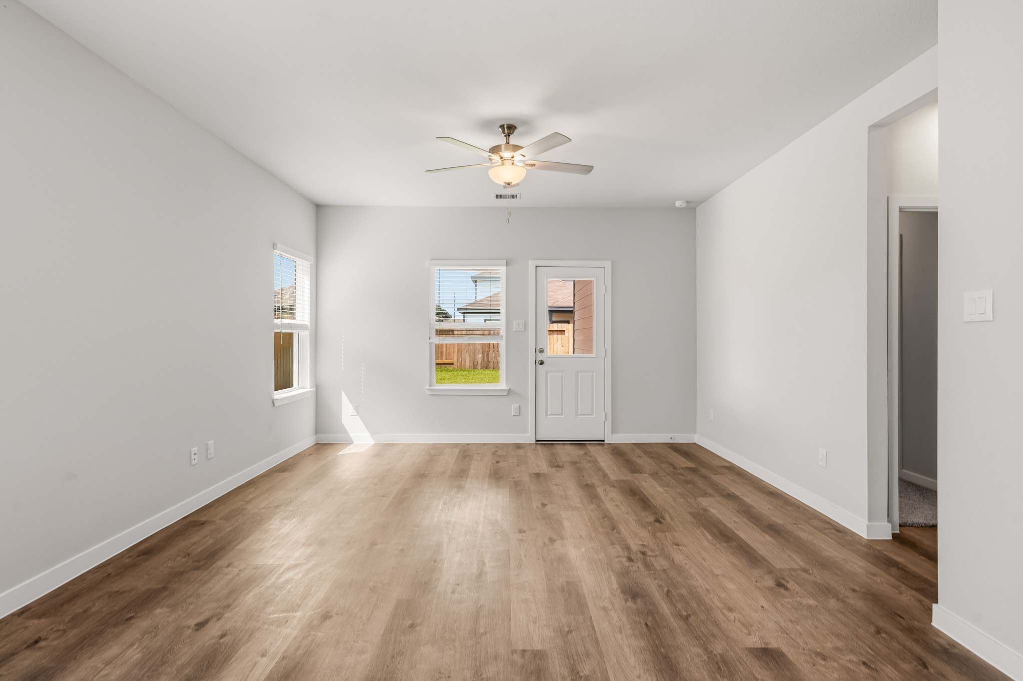 A room with a wood floor and a ceiling fan.