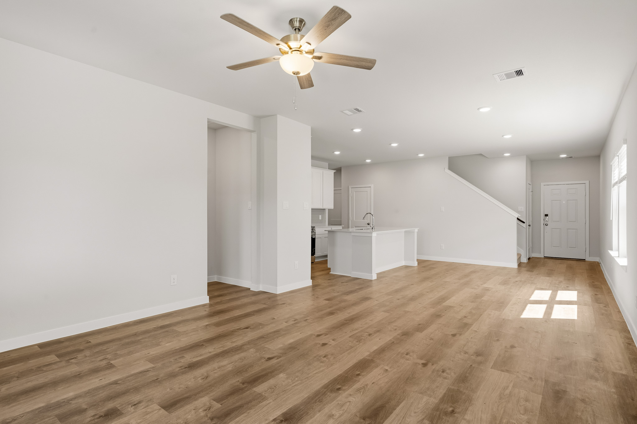 A room with a wood floor and a ceiling fan.