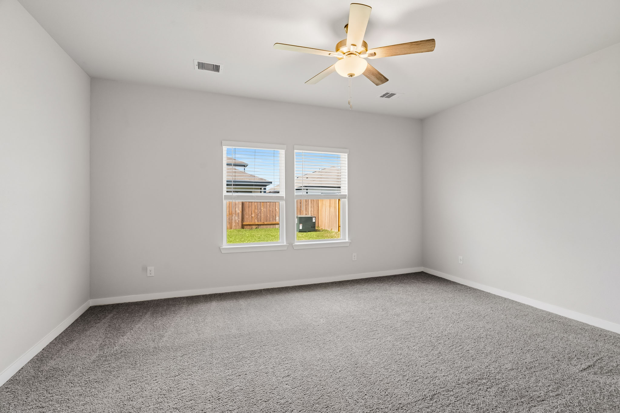 A room with a ceiling fan and a window.