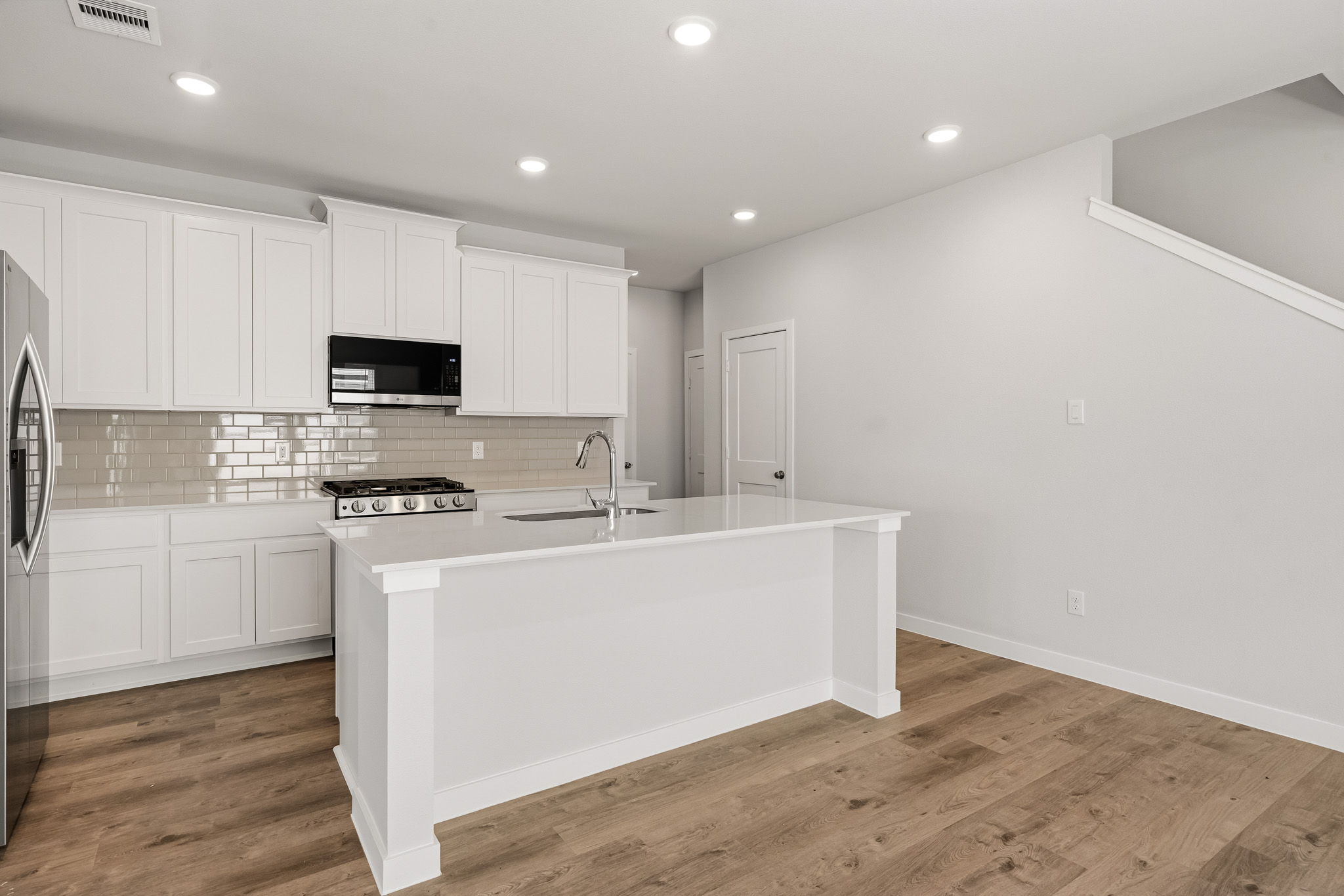 A kitchen with white cabinets.