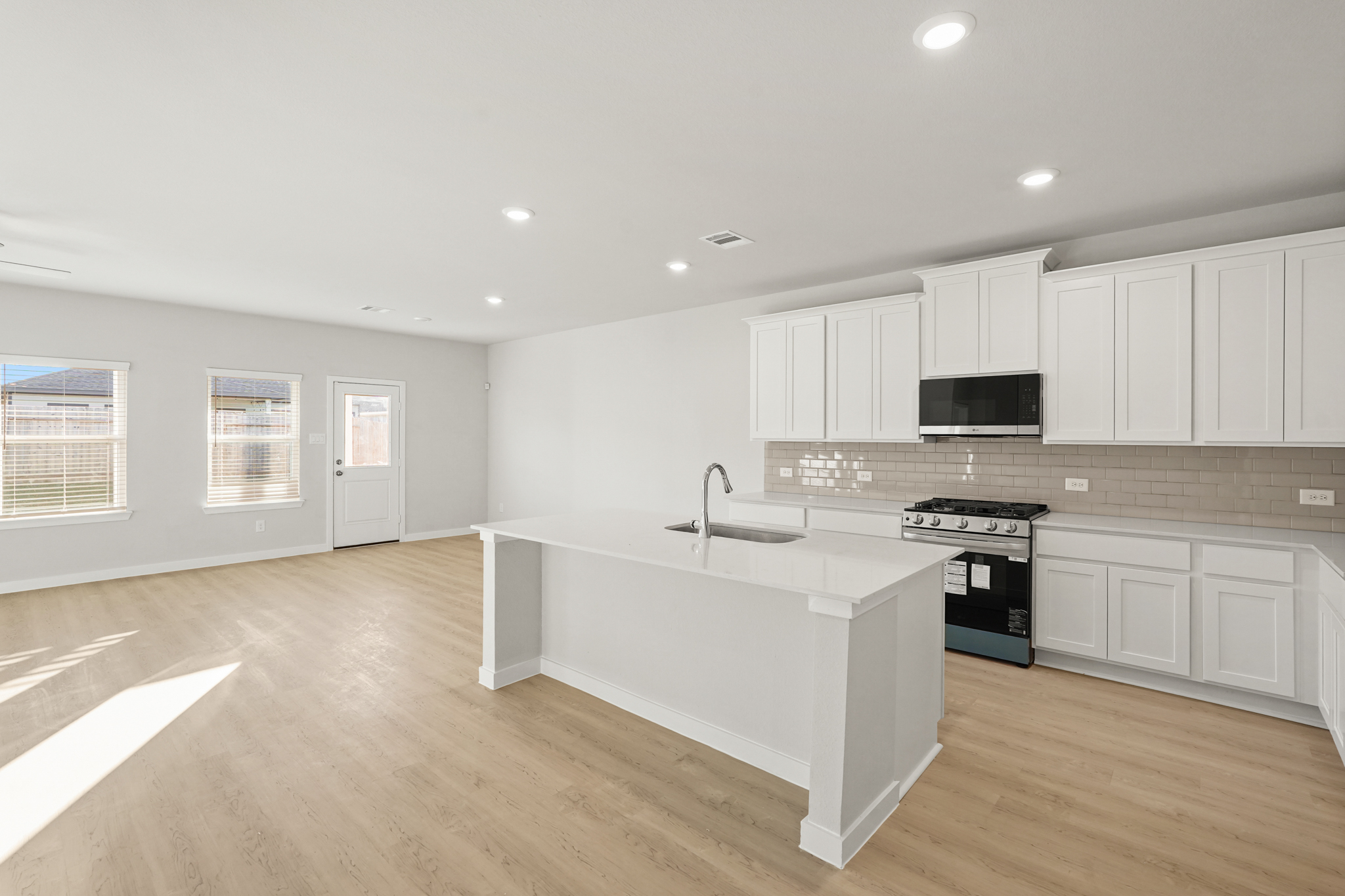 A kitchen with white cabinets.