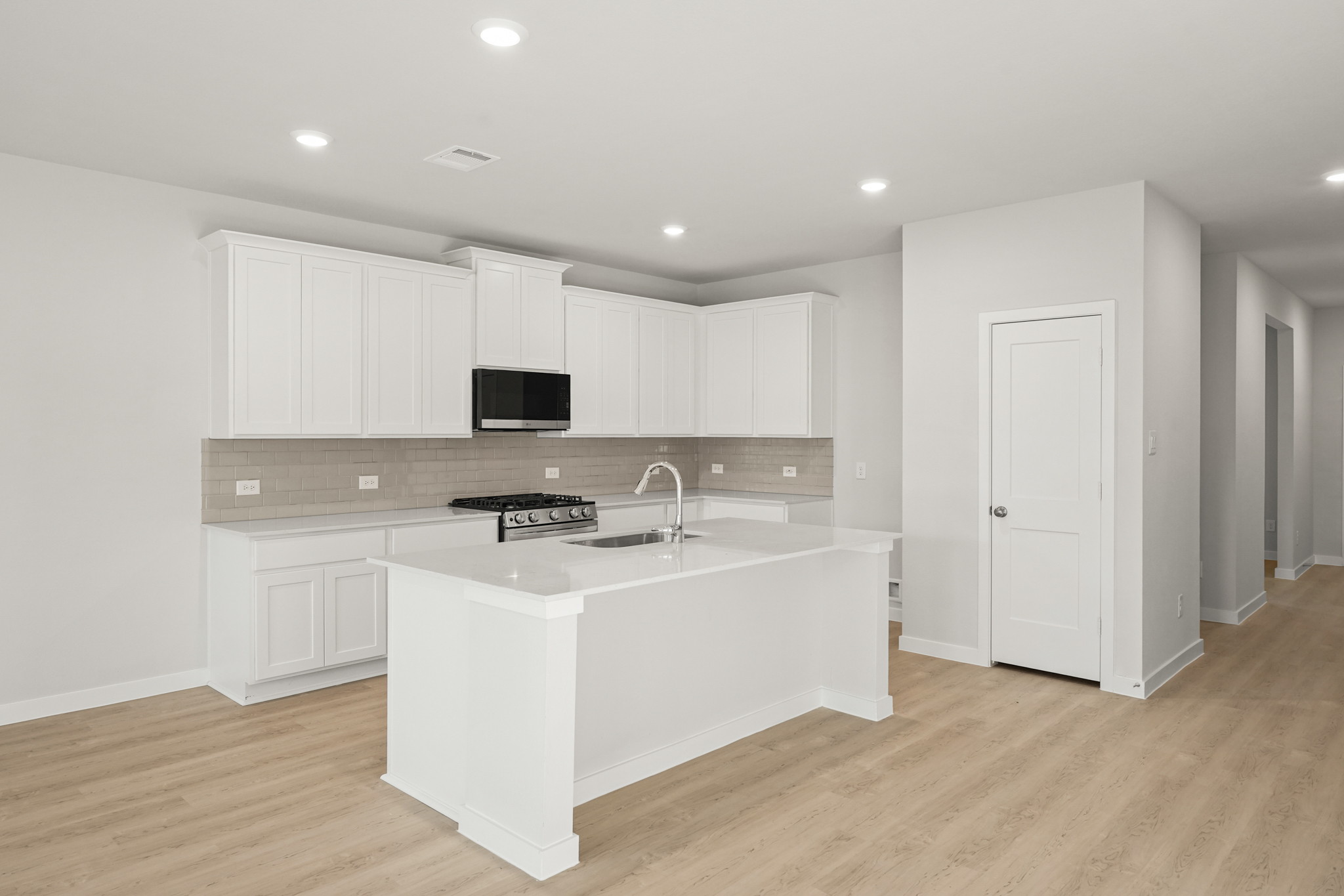 A kitchen with white cabinets.