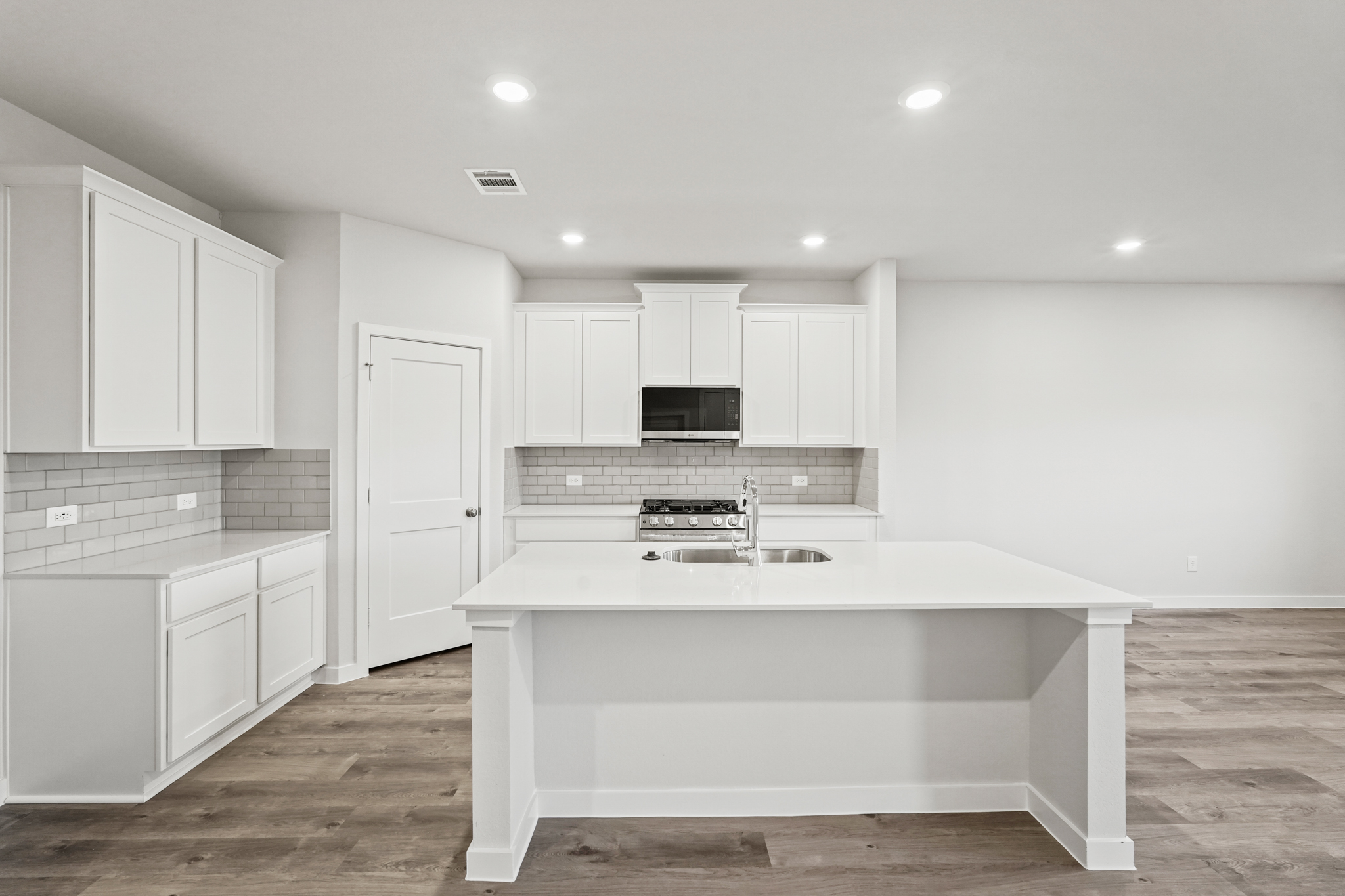 A kitchen with white cabinets.