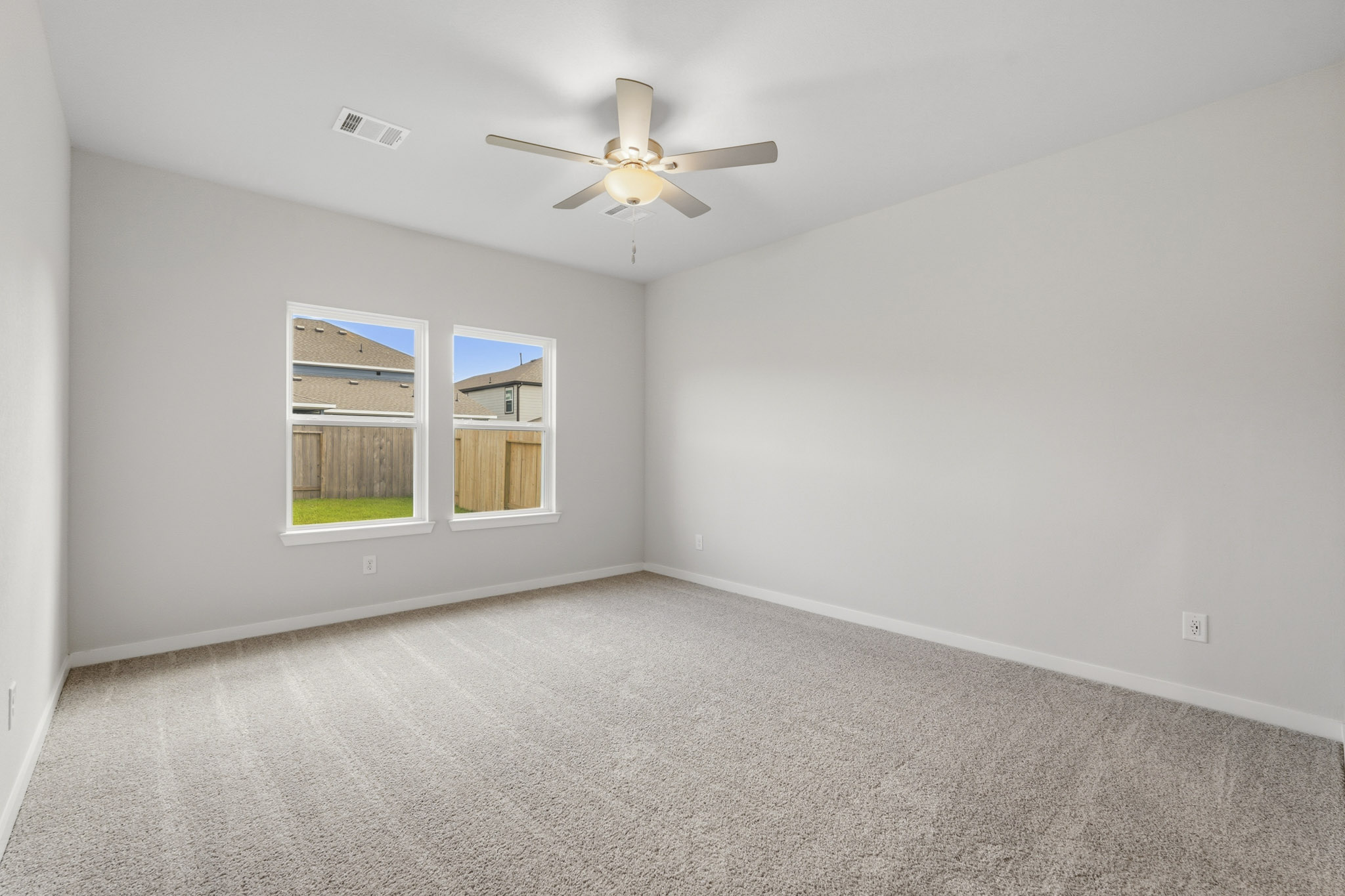 A room with a ceiling fan and a window.