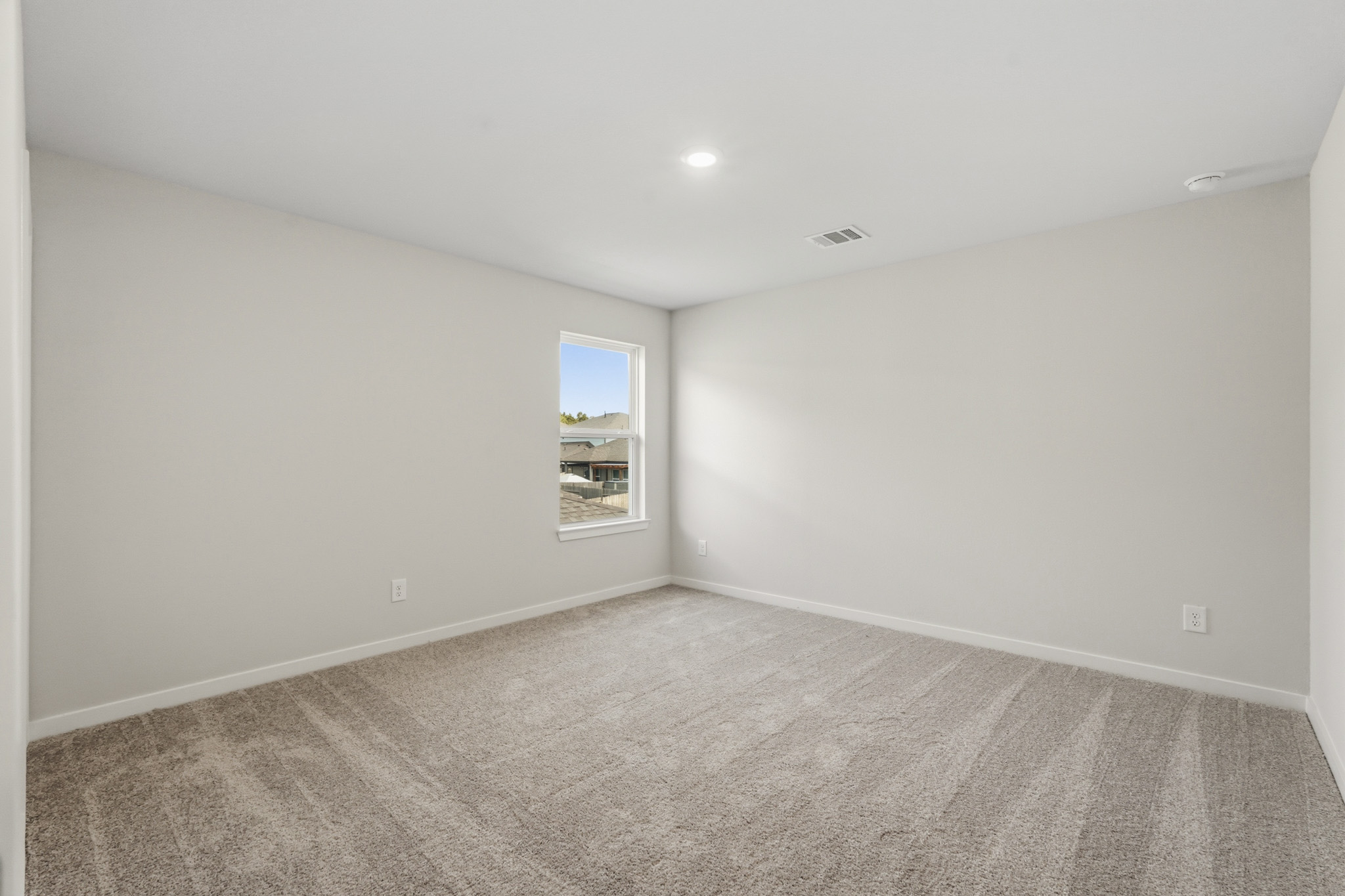 A room with a carpet and a window.
