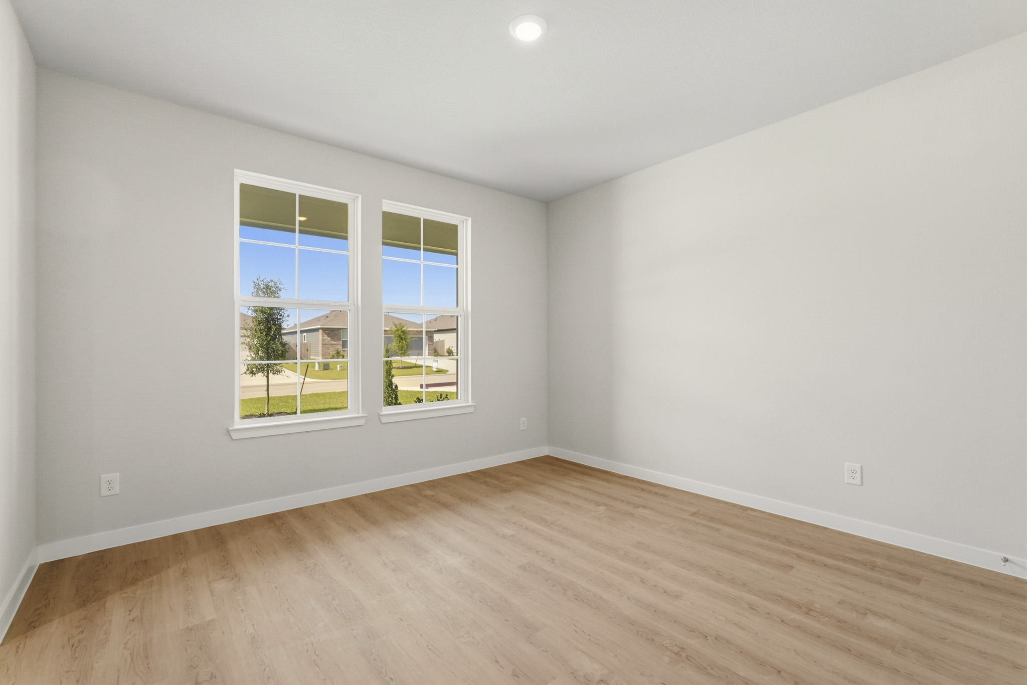 A room with a wood floor and a window with a wood floor.