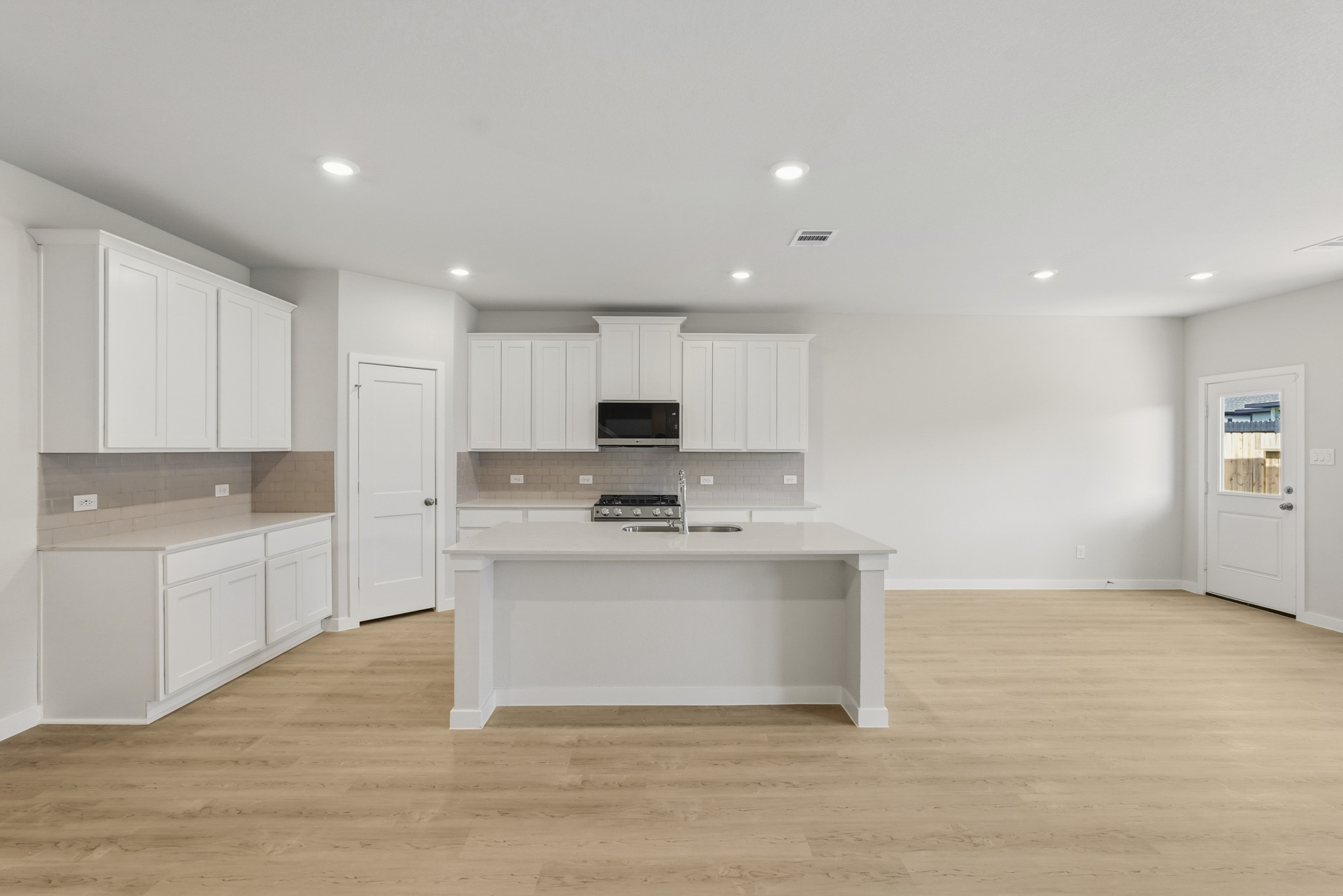 A kitchen with white cabinets.