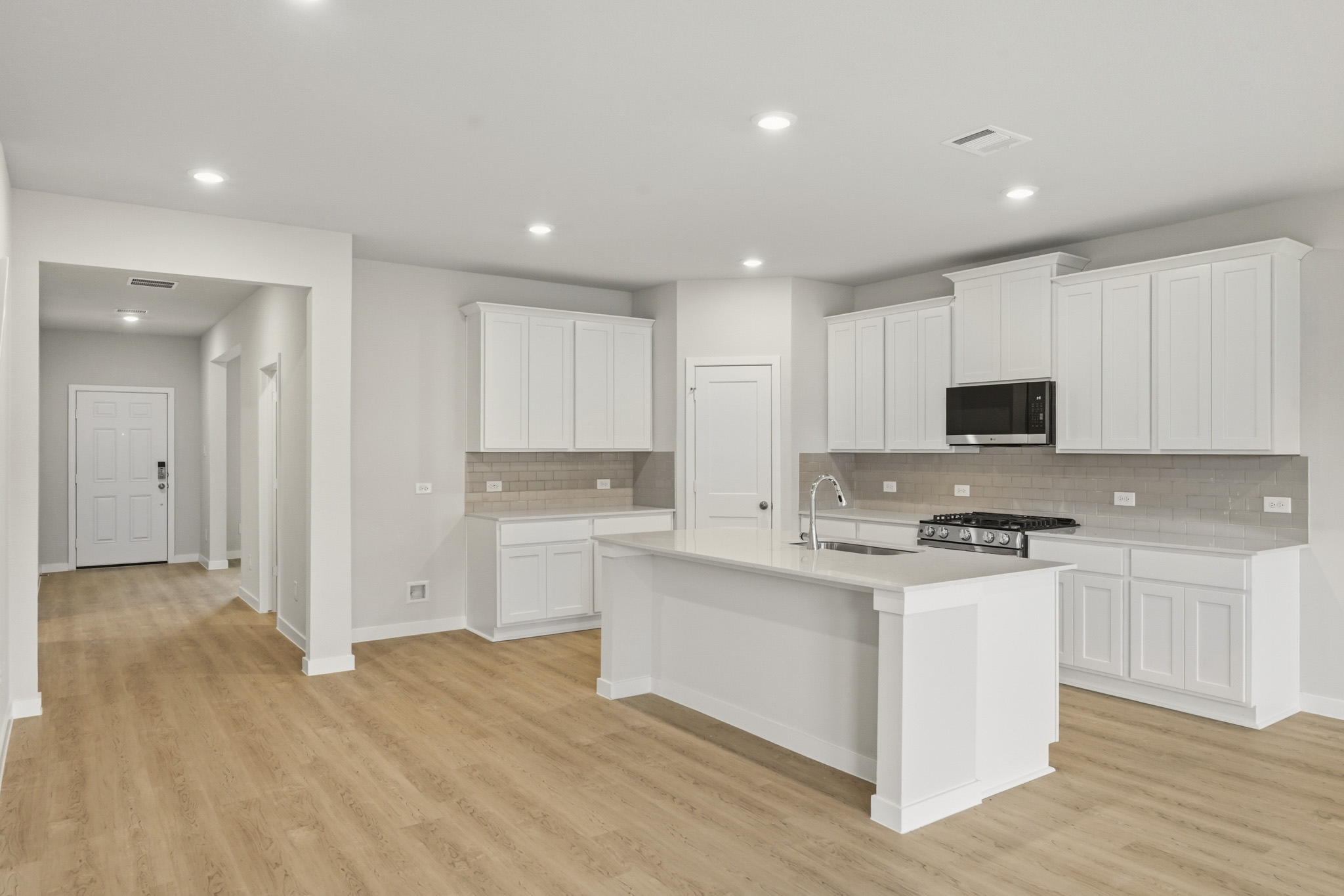 A kitchen with white cabinets.