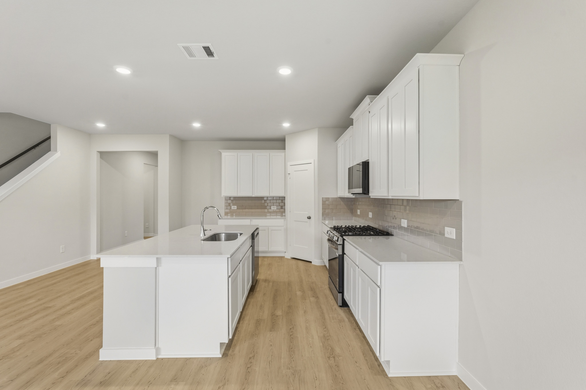 A kitchen with white cabinets.