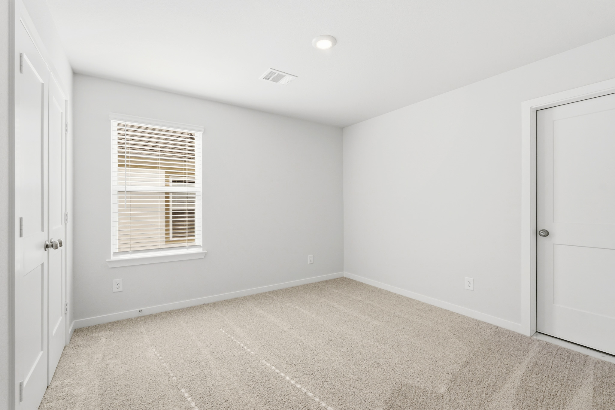 A room with white walls and a window.