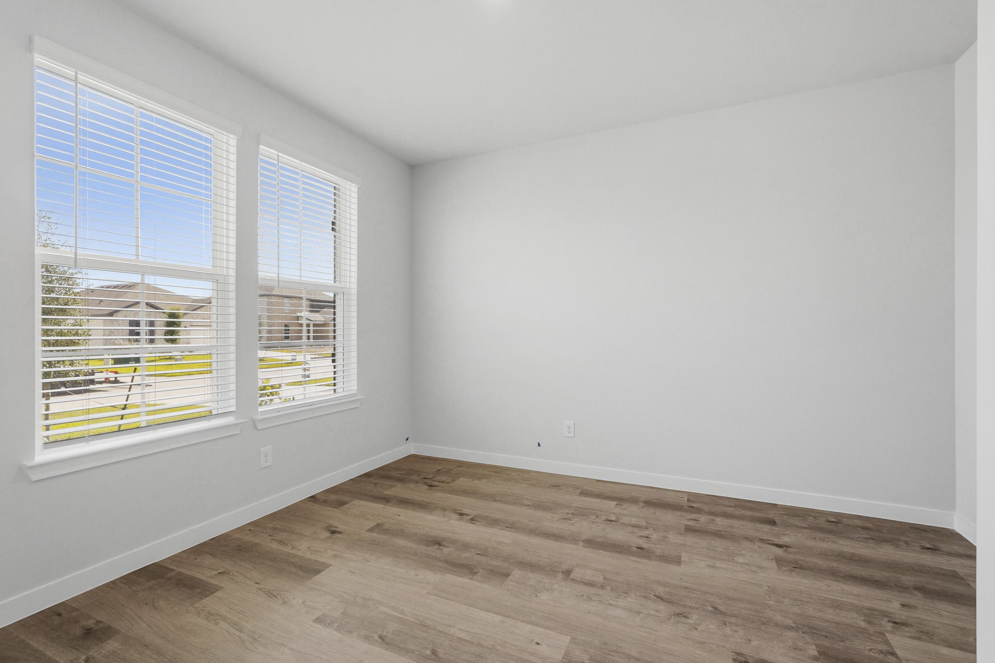 A room with a wood floor and windows.