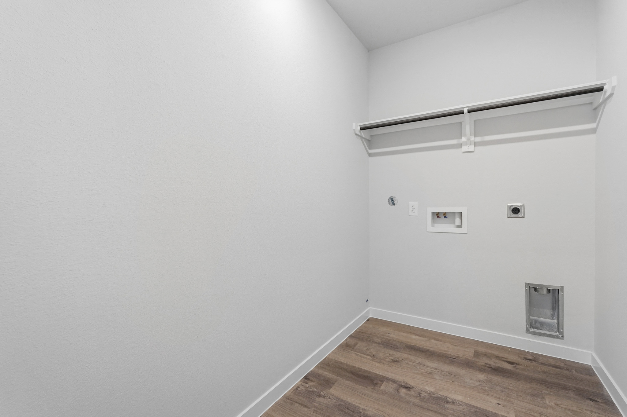 A white room with a wood floor.