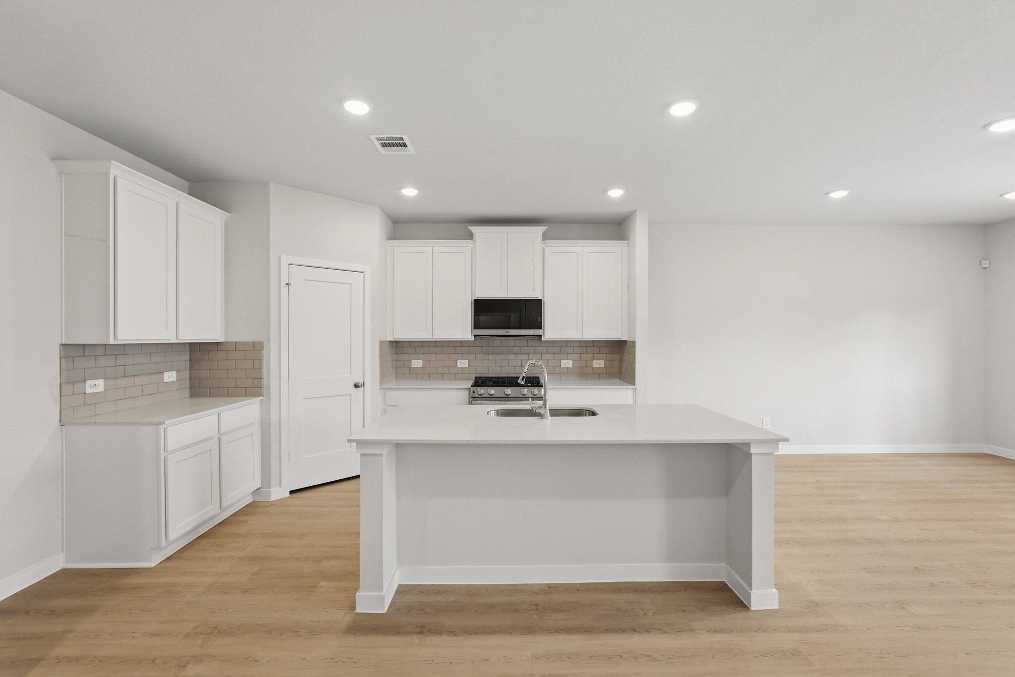 A kitchen with white cabinets.
