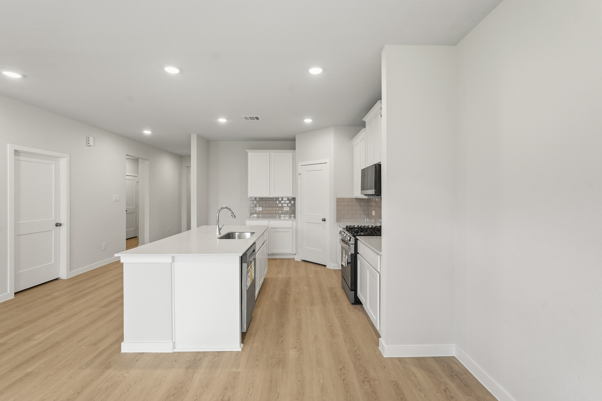 A kitchen with white cabinets.