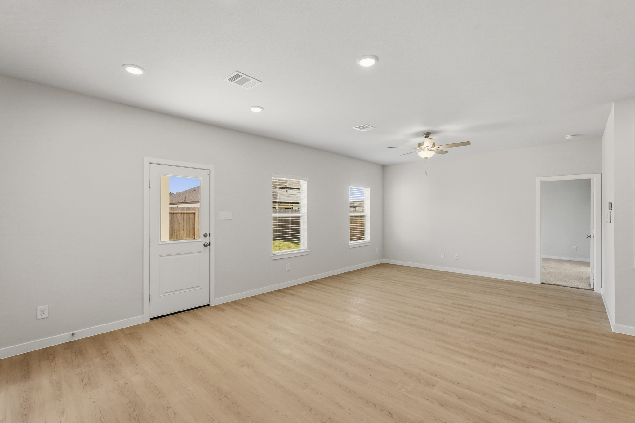 A room with a wood floor and a ceiling fan.