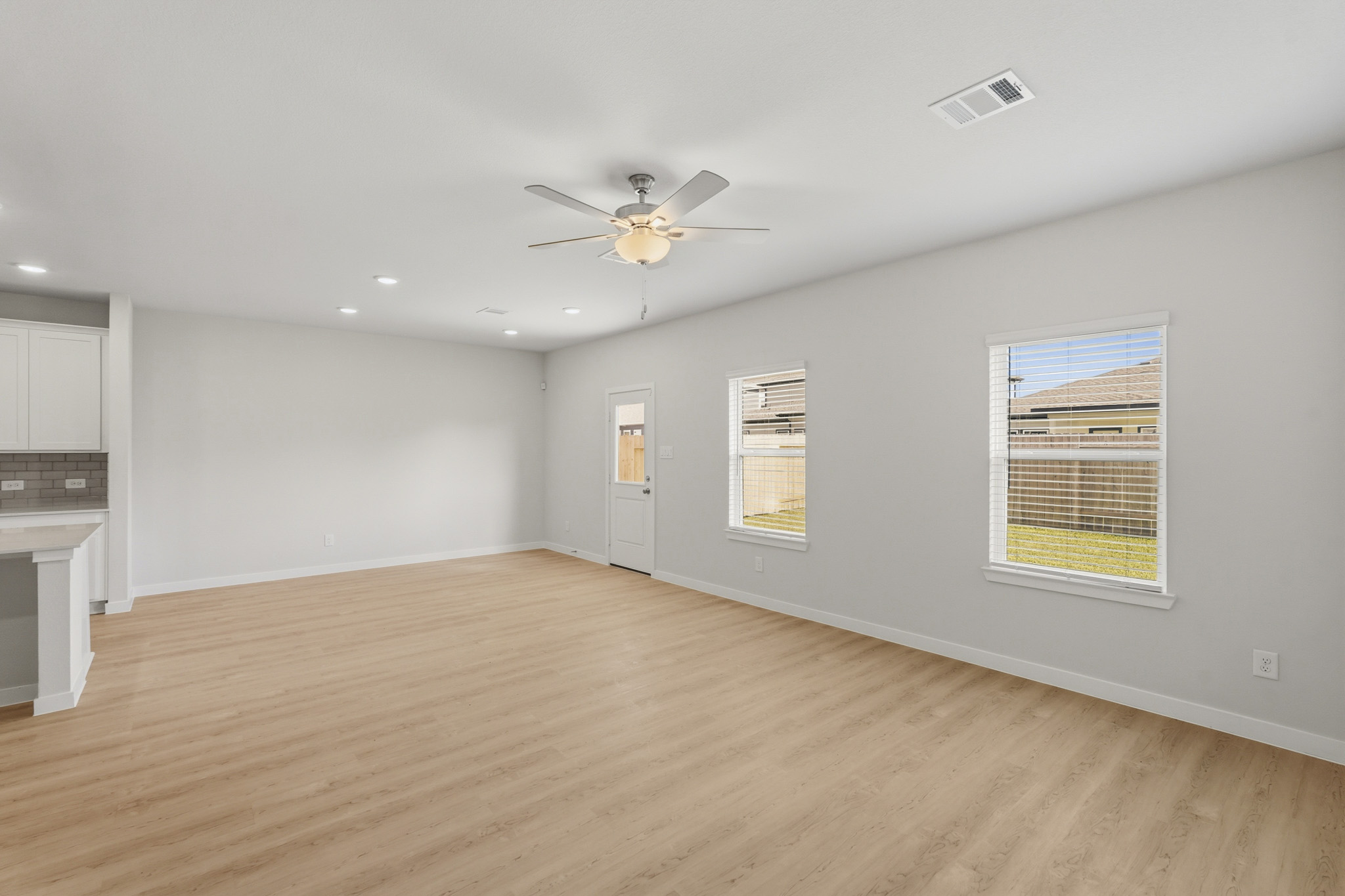 A room with a wood floor and a ceiling fan.