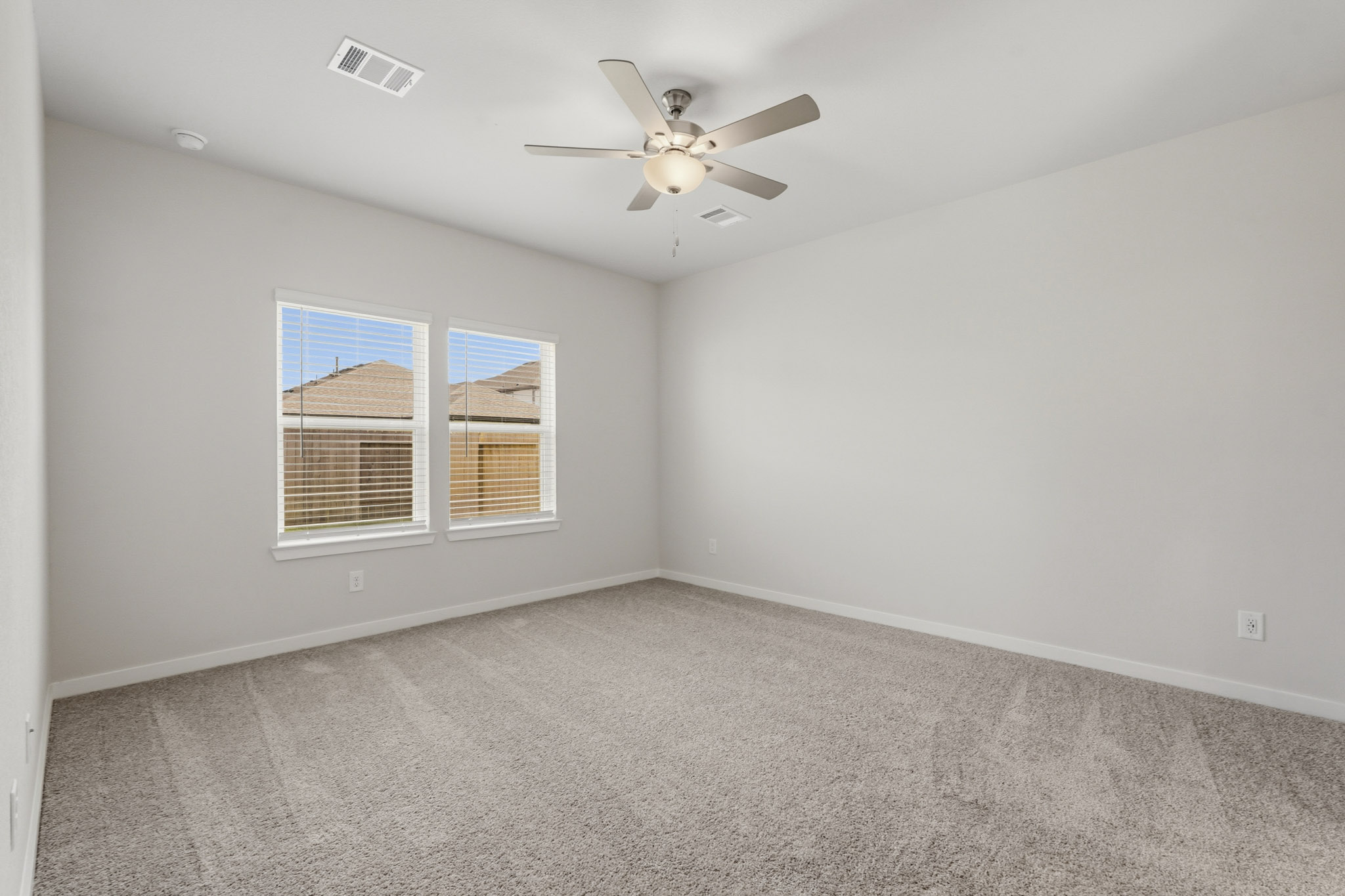 A room with a ceiling fan and a window.
