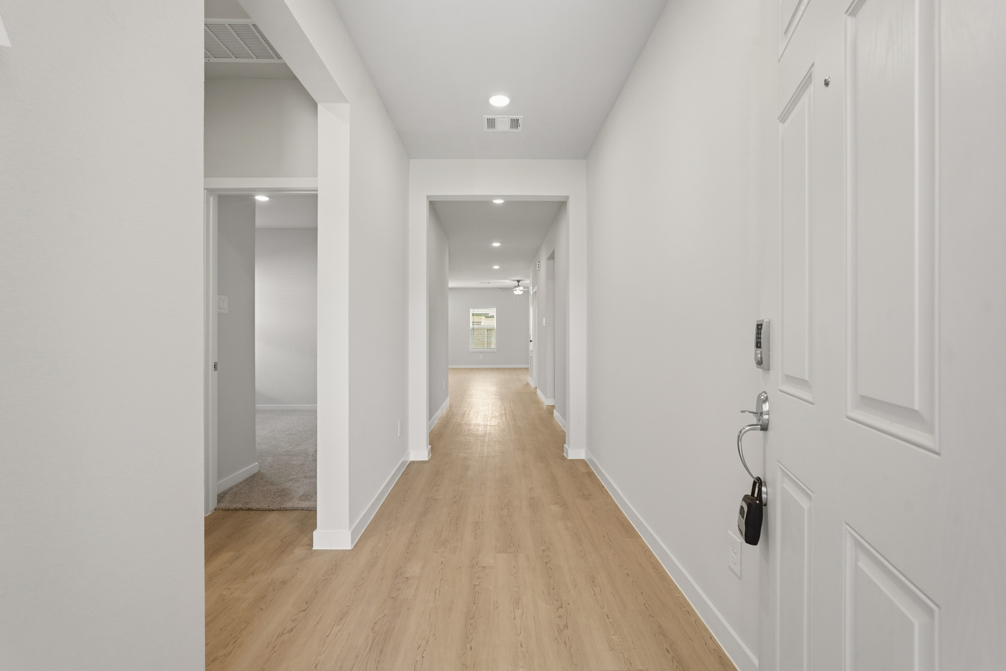 A long hallway with white doors.