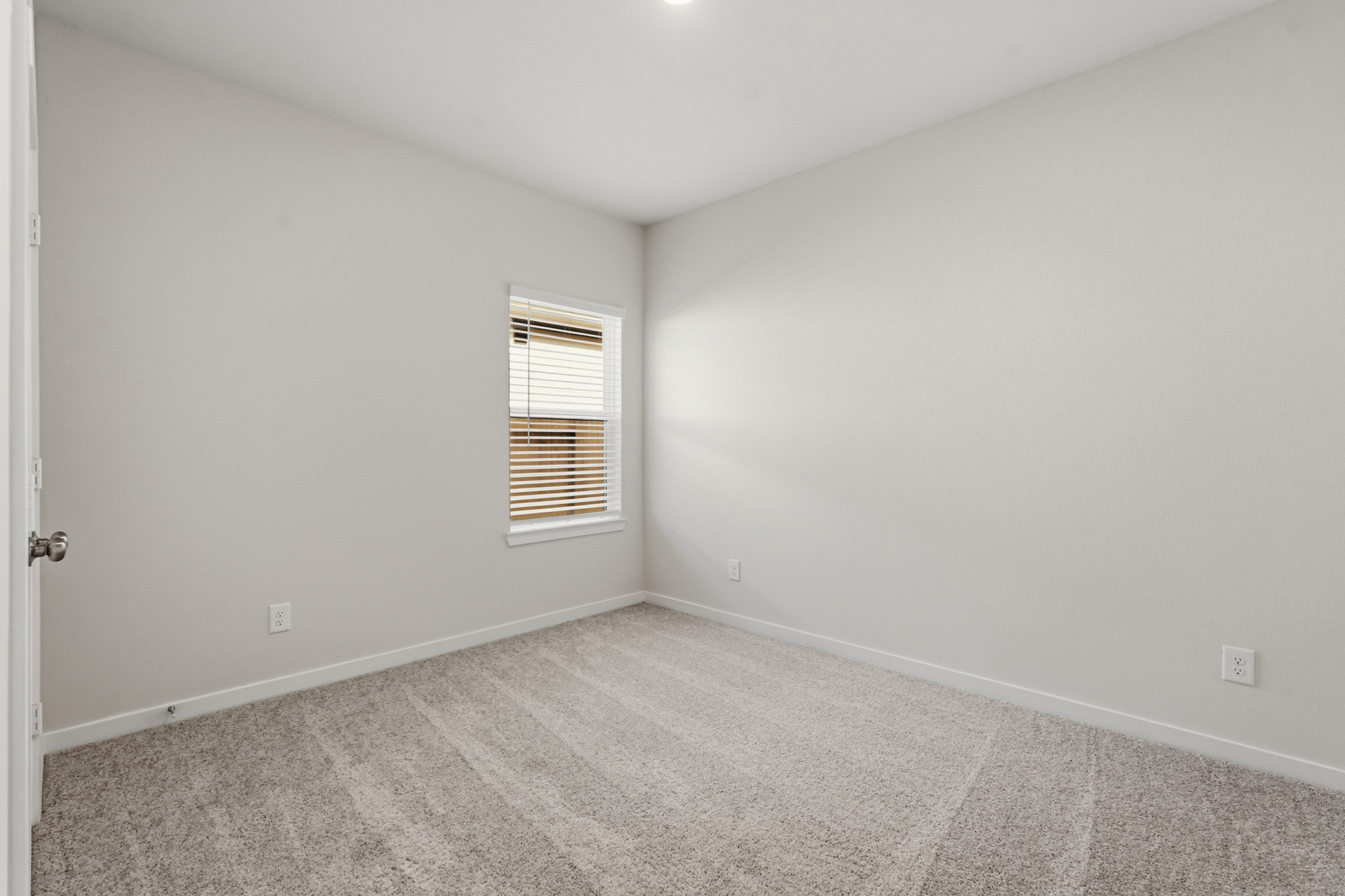 A room with a window and a carpet.