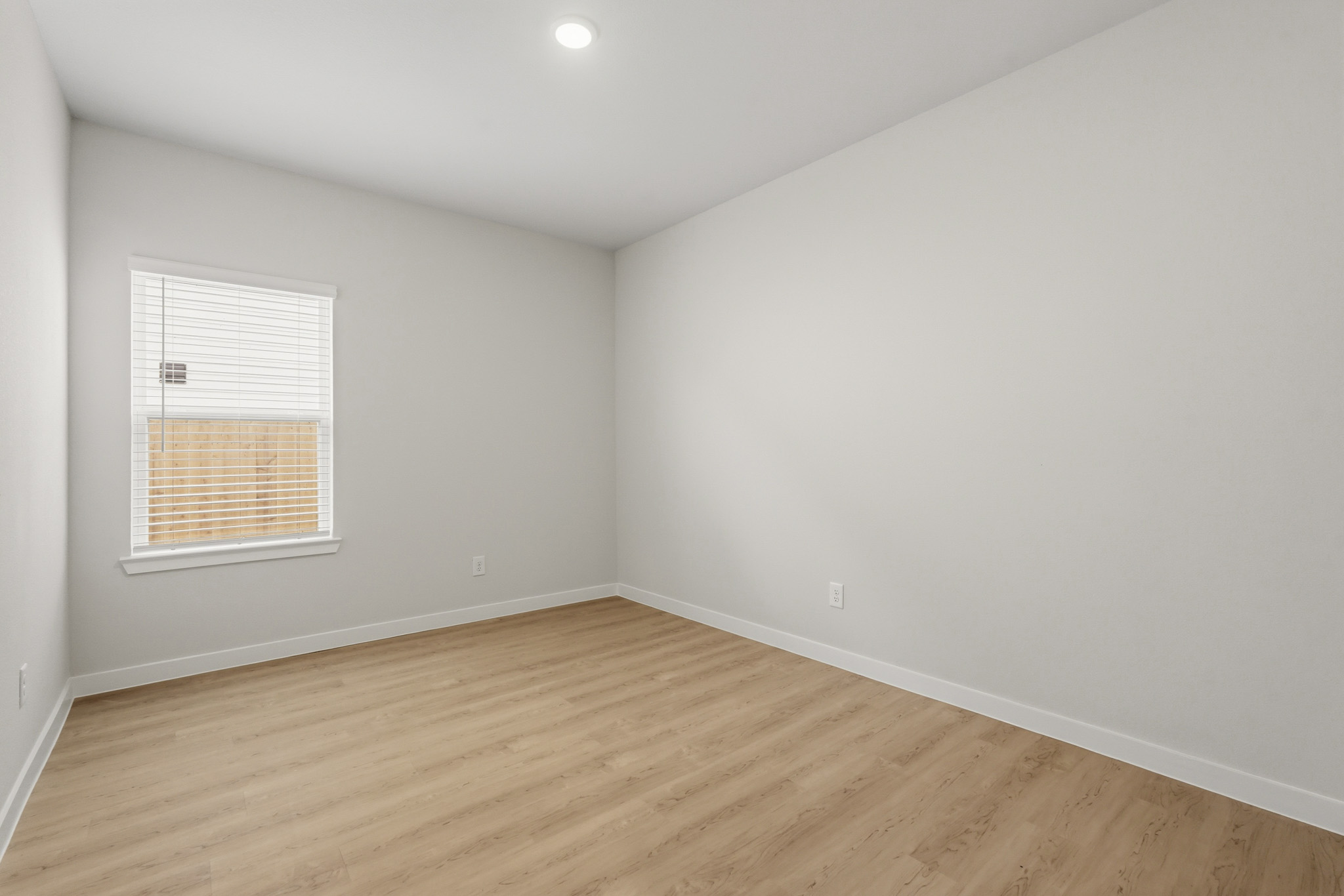 A room with a wood floor and a window.