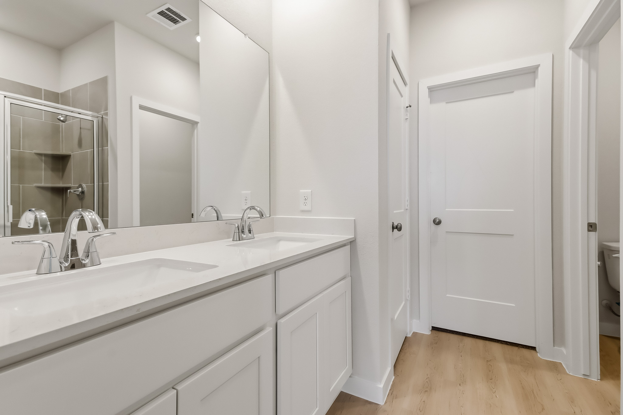 A bathroom with white cabinets.