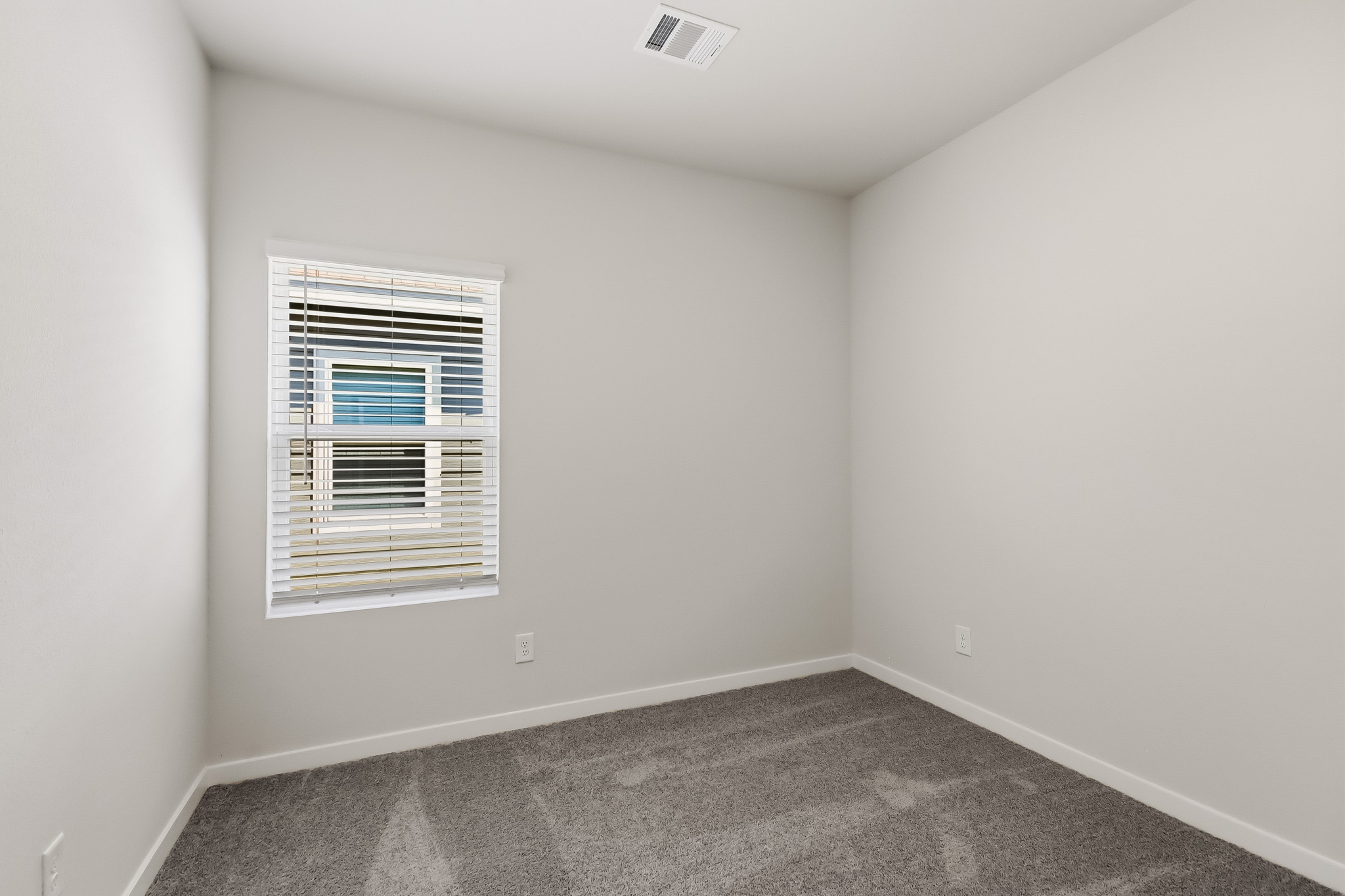 A room with a vent and a window.