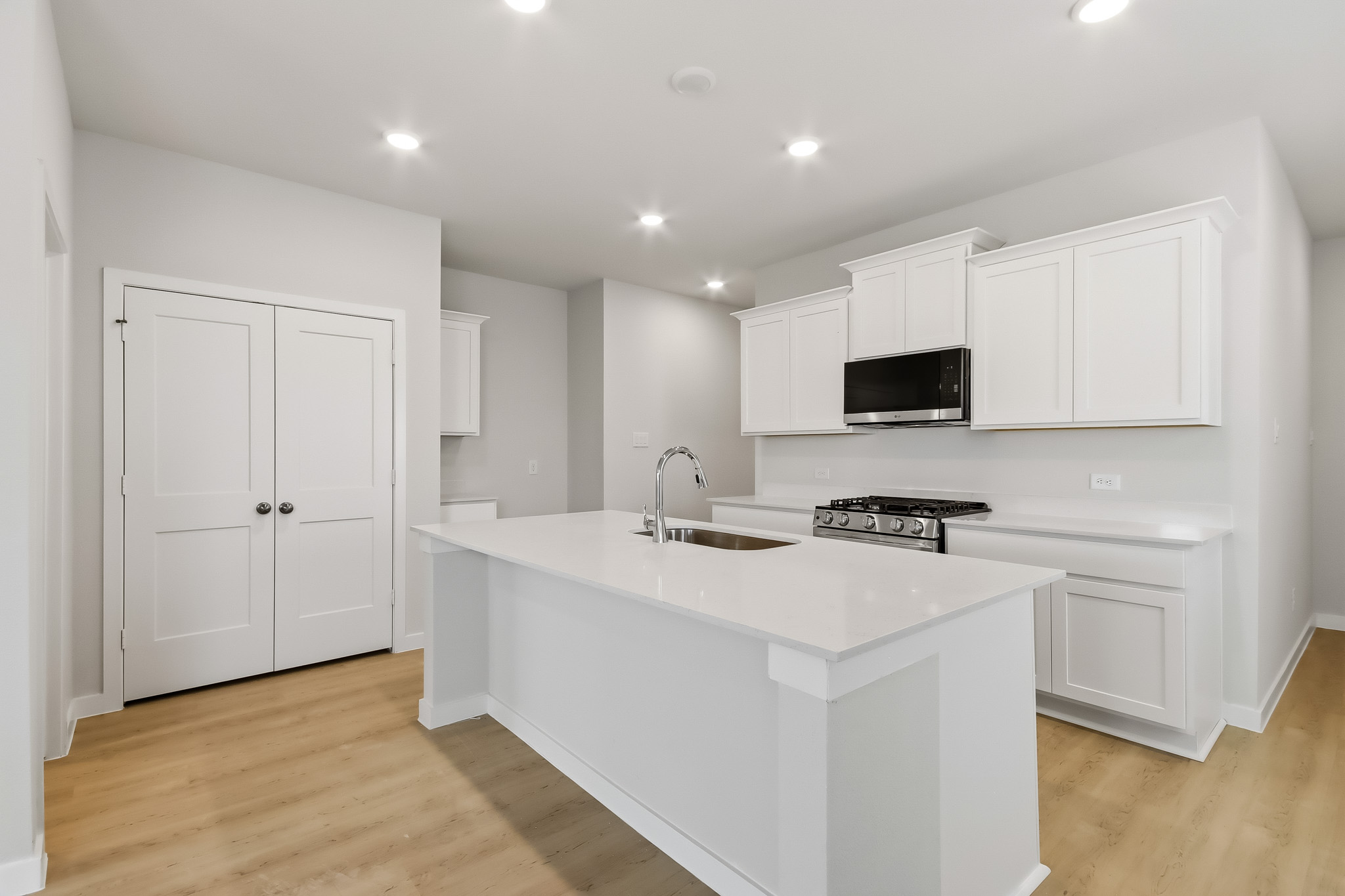 A kitchen with white cabinets.