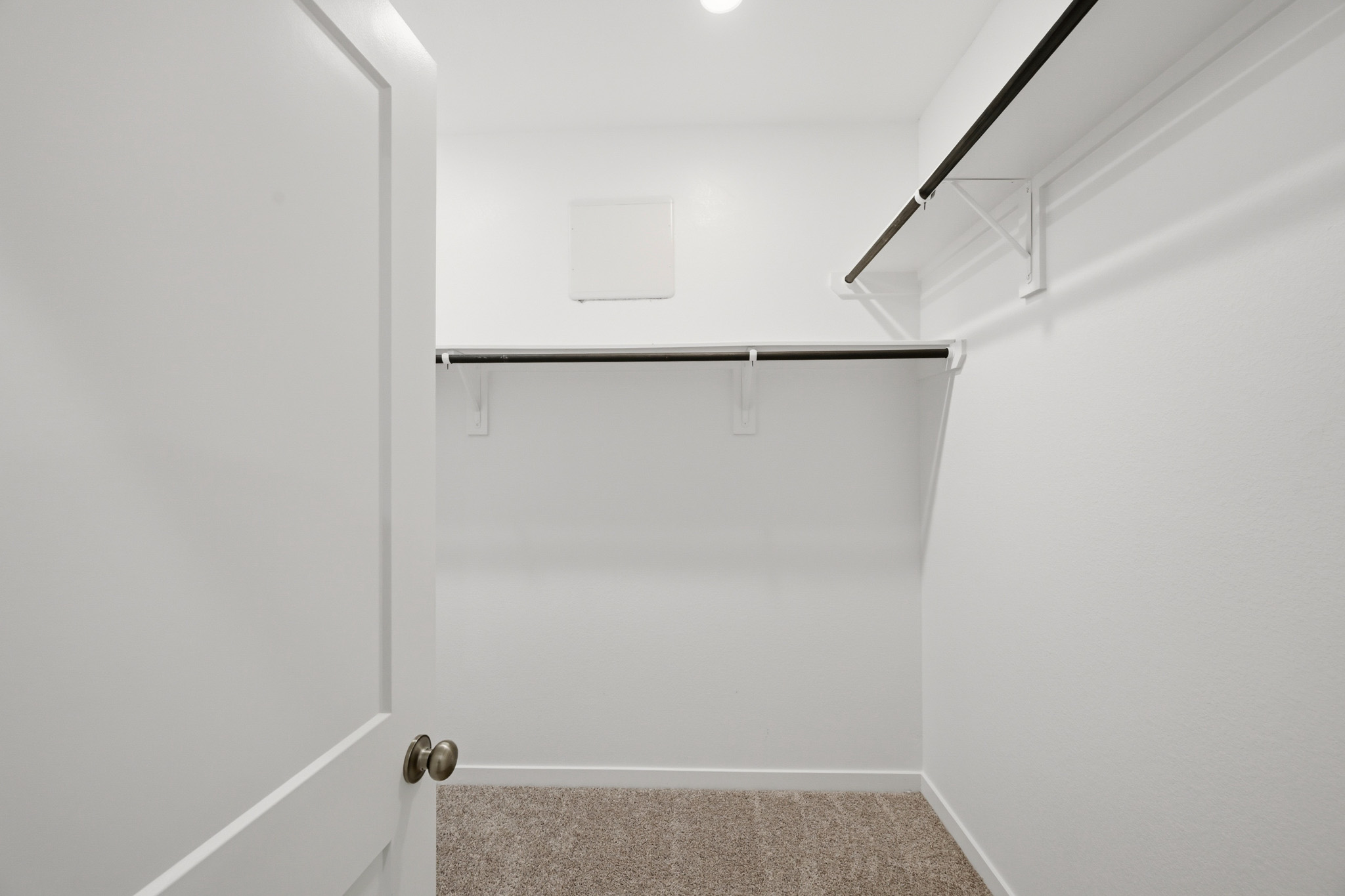 A white door with a metal bar.