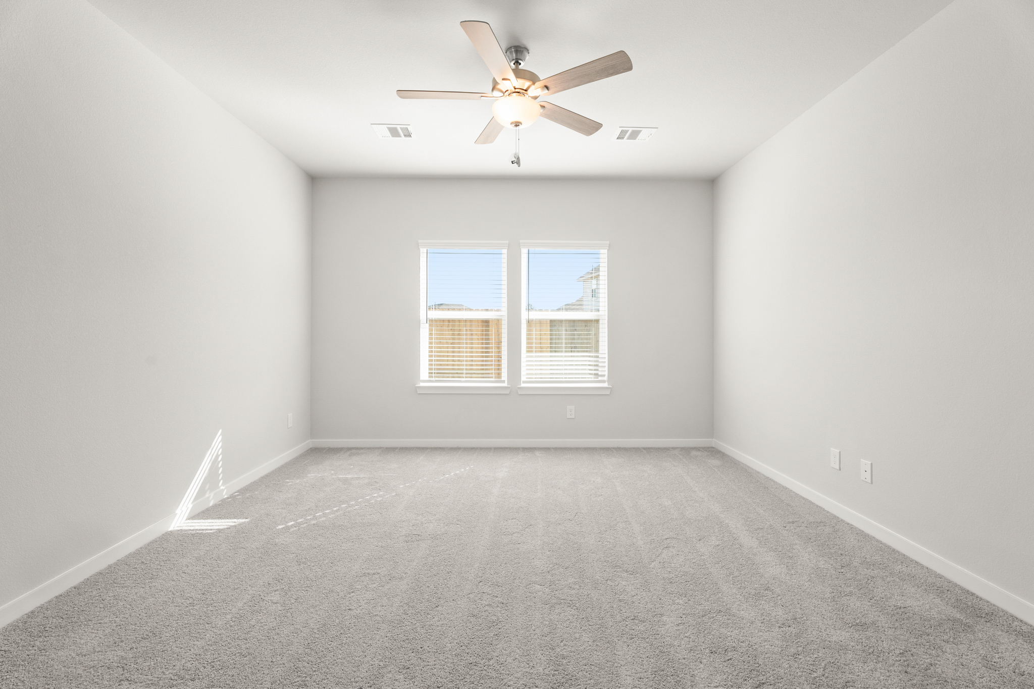A room with a ceiling fan and a window.