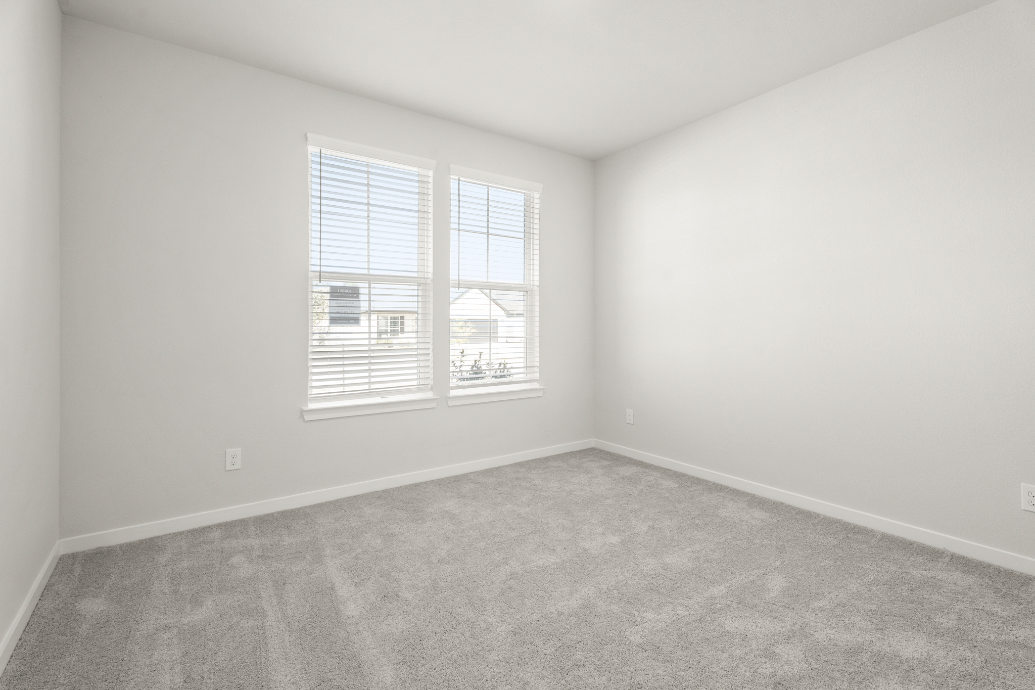 A room with a window and a carpet.